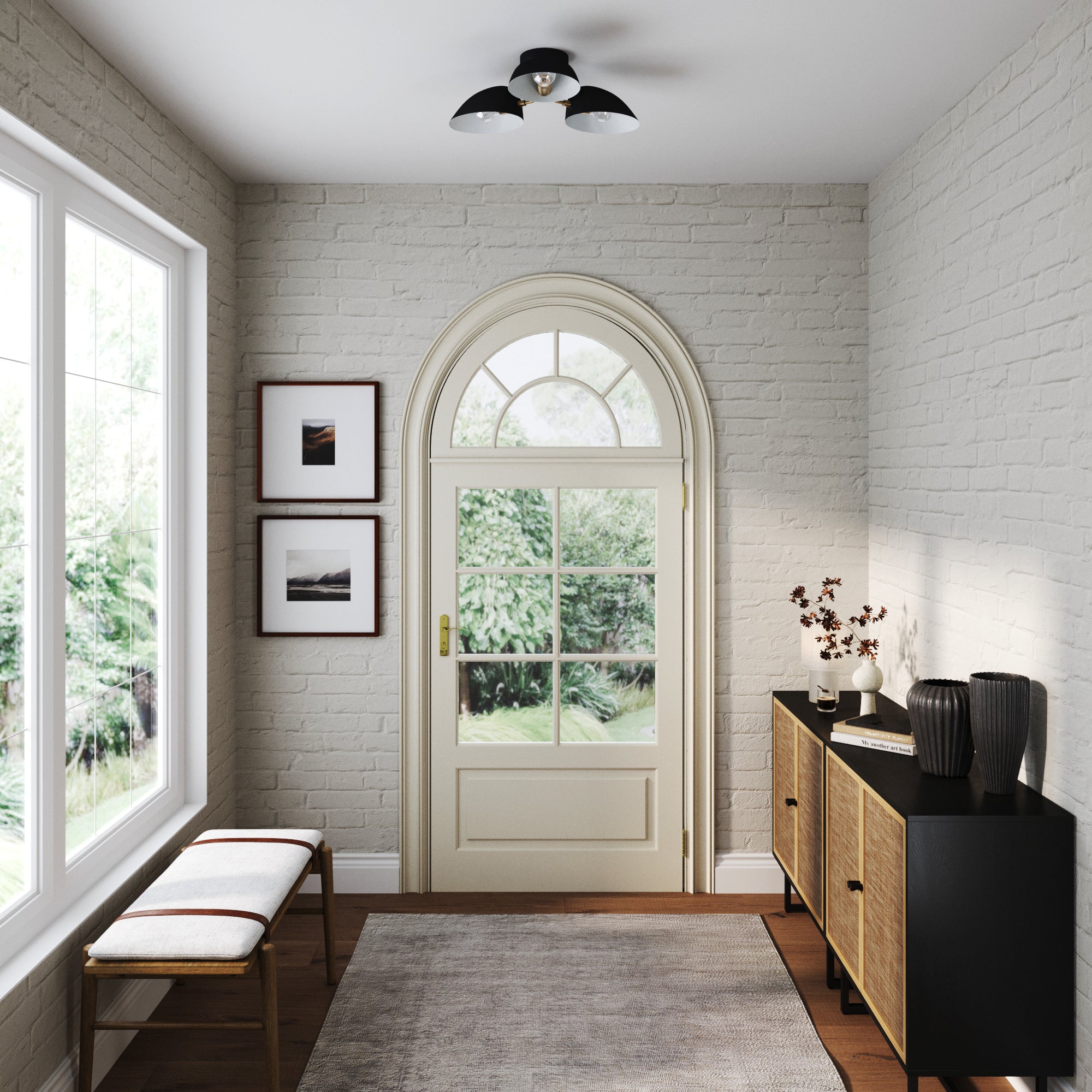 Bright entryway with a white brick wall, arched glass door, two framed photos, a bench with cushions, and a console table with vases and decor. Large windows reveal greenery outside.