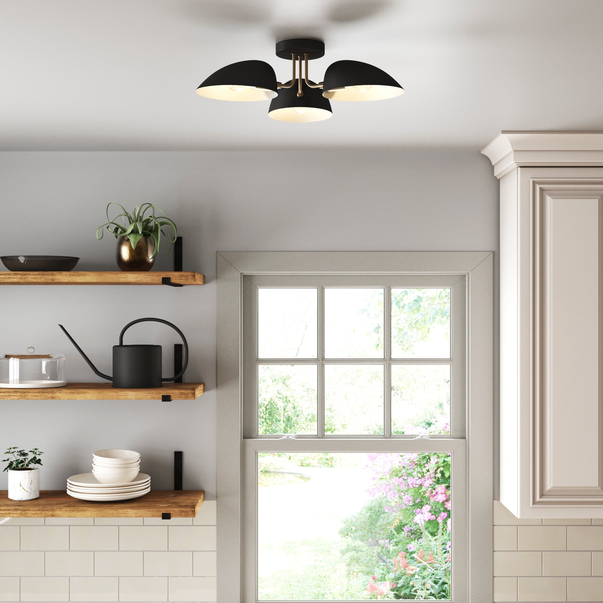 A modern kitchen with floating wooden shelves and a garden-view window features the Nathan James Metal 3-Arm Flush Mount Ceiling Light in black, offering adjustable shades for a sleek, modern retro touch.