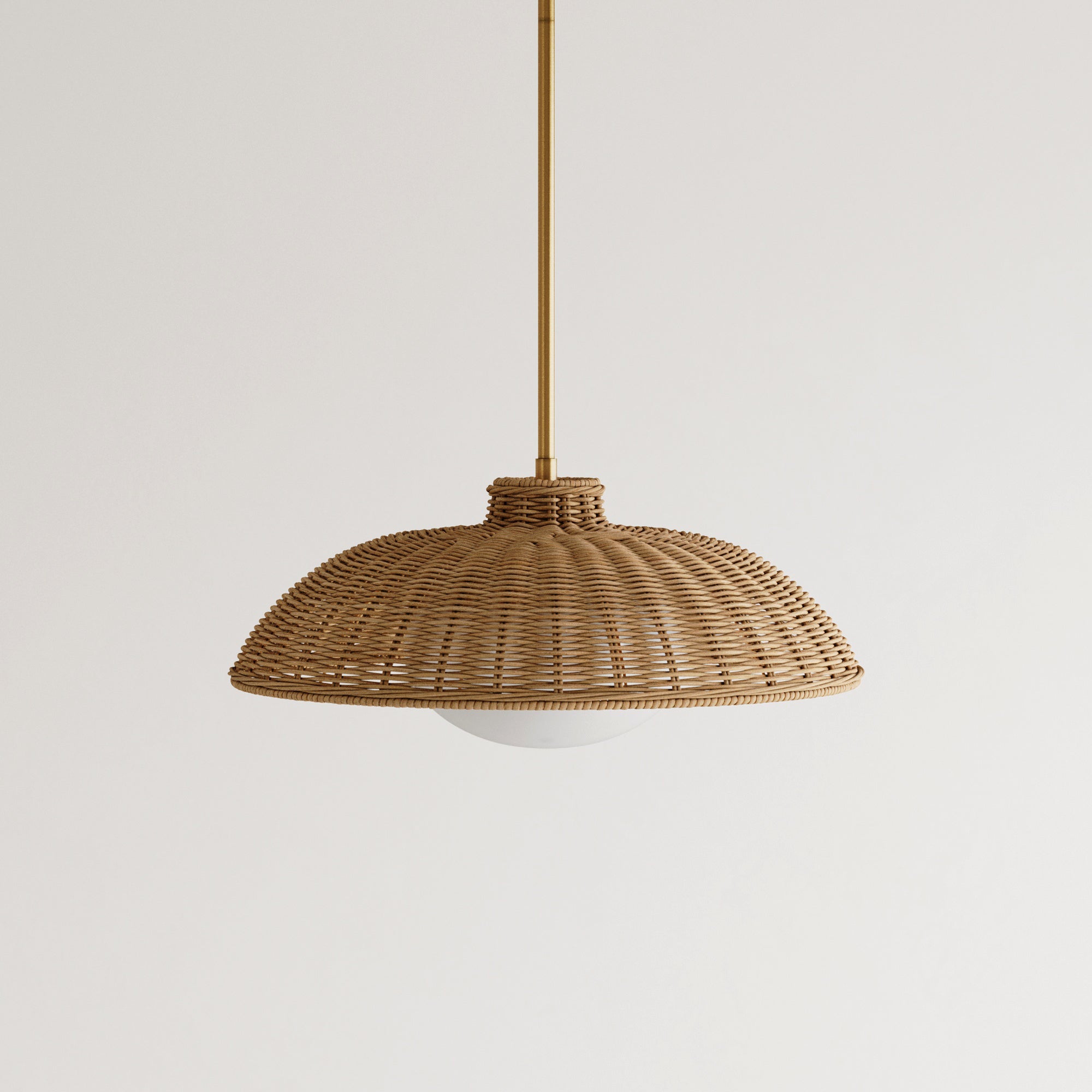 A woven rattan pendant light with a dome-shaped shade hangs from a thin brass rod against a plain white background.