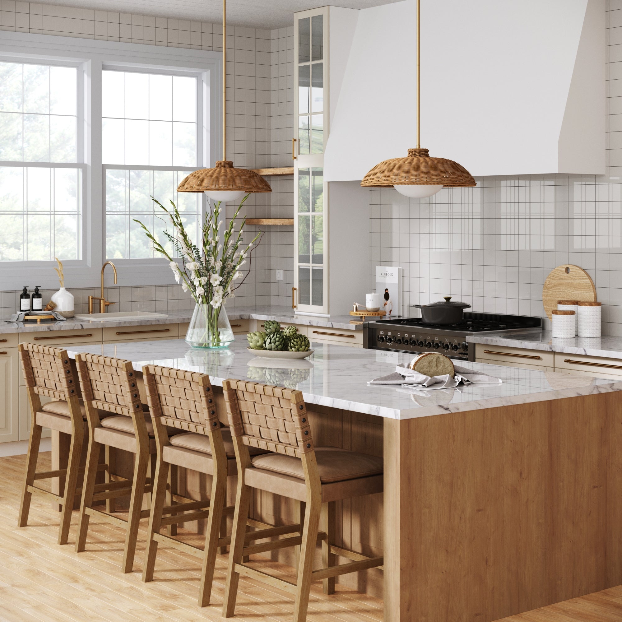 Modern kitchen featuring light wood cabinetry, a marble island with four cushioned chairs, the Nathan James Boho Rattan Pendant Light Fixture with Glass Diffuser, a vase of flowers, and large windows bringing in natural light.