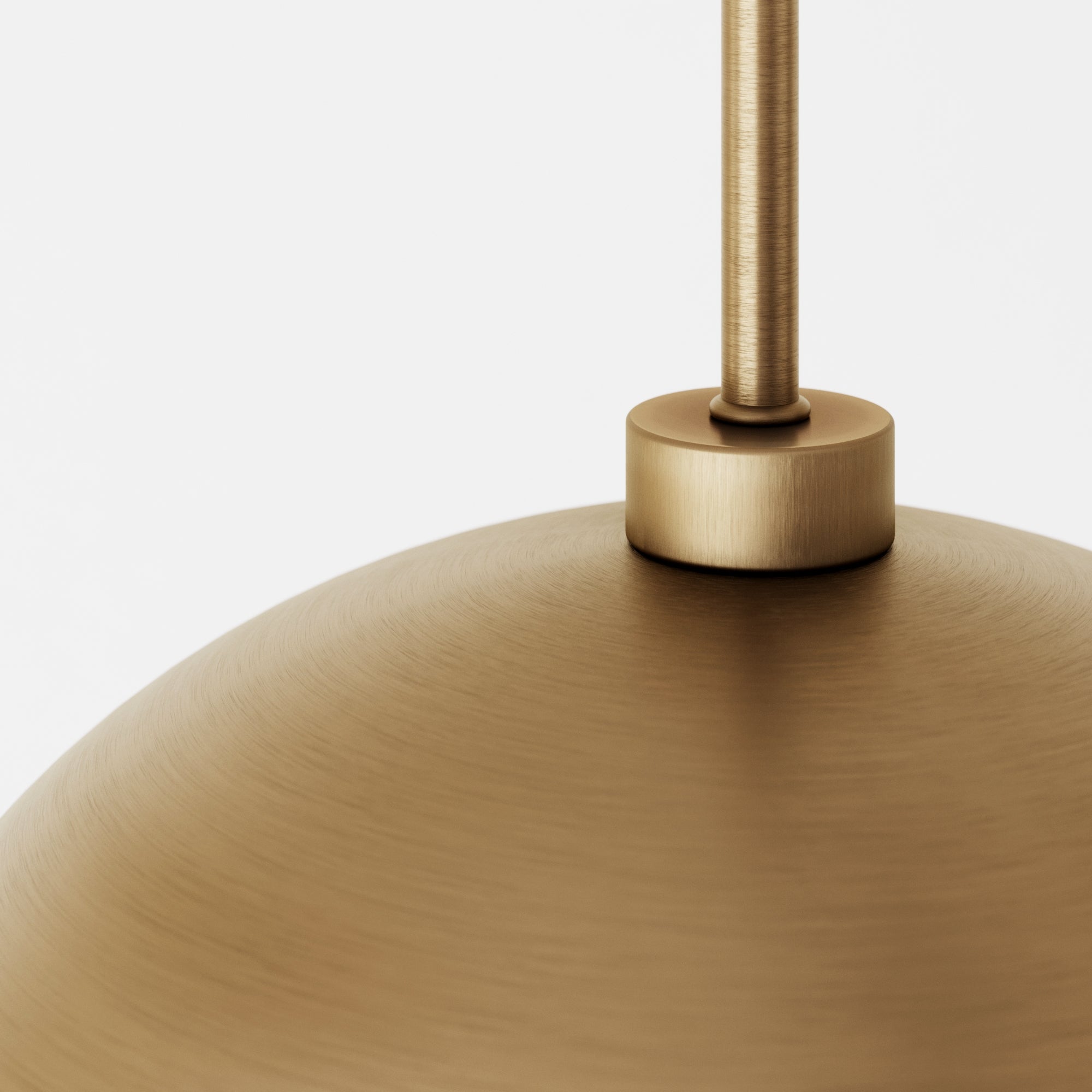 Close-up of a brushed brass pendant light fixture with a smooth, dome-shaped surface and a cylindrical connection to the hanging rod, set against a plain white background.