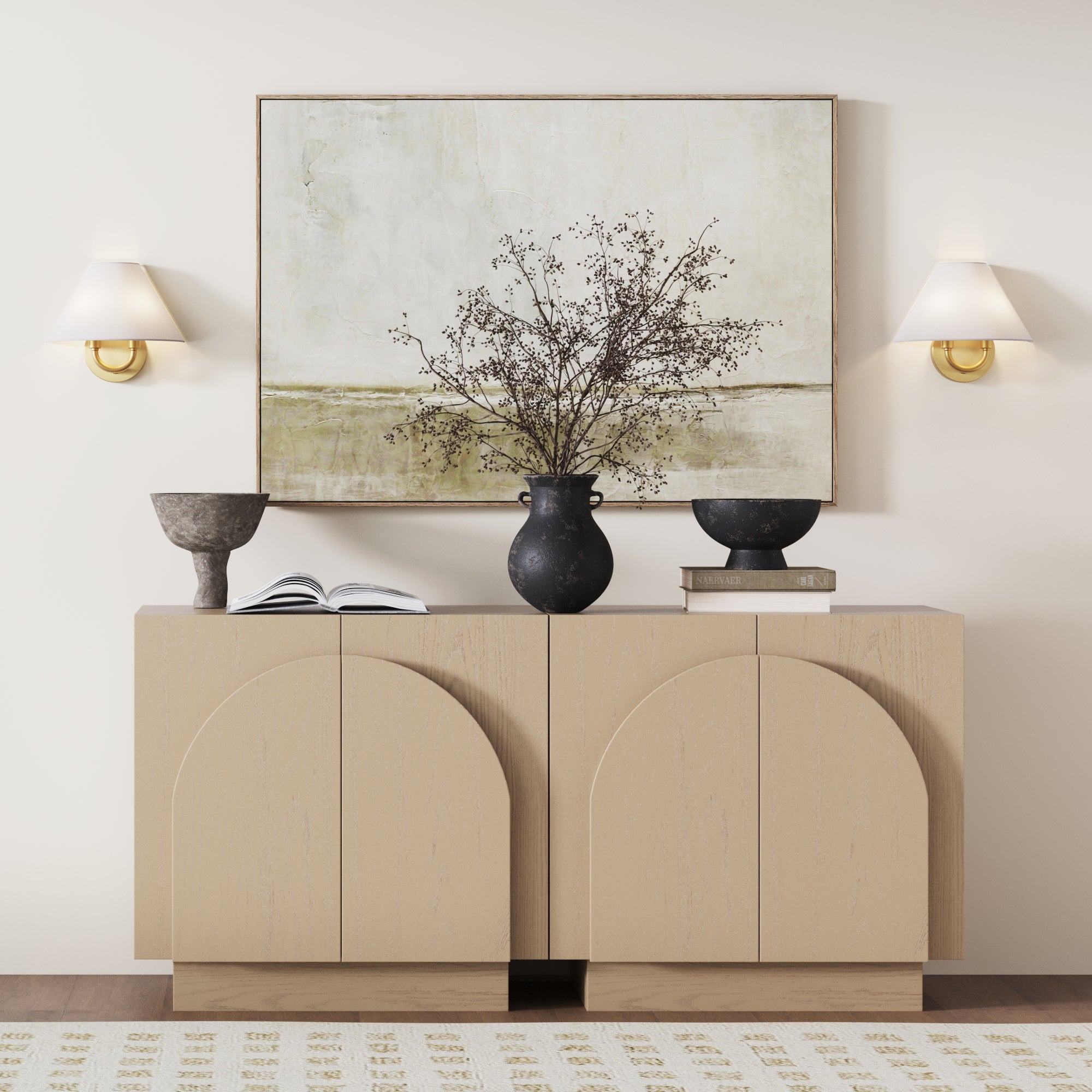 A beige sideboard displays black vases, bowls, and books. Above, a minimal landscape painting is flanked by Nathan James Modern Farmhouse Wall Lights with linen shades—the perfect modern accent (set of 2).