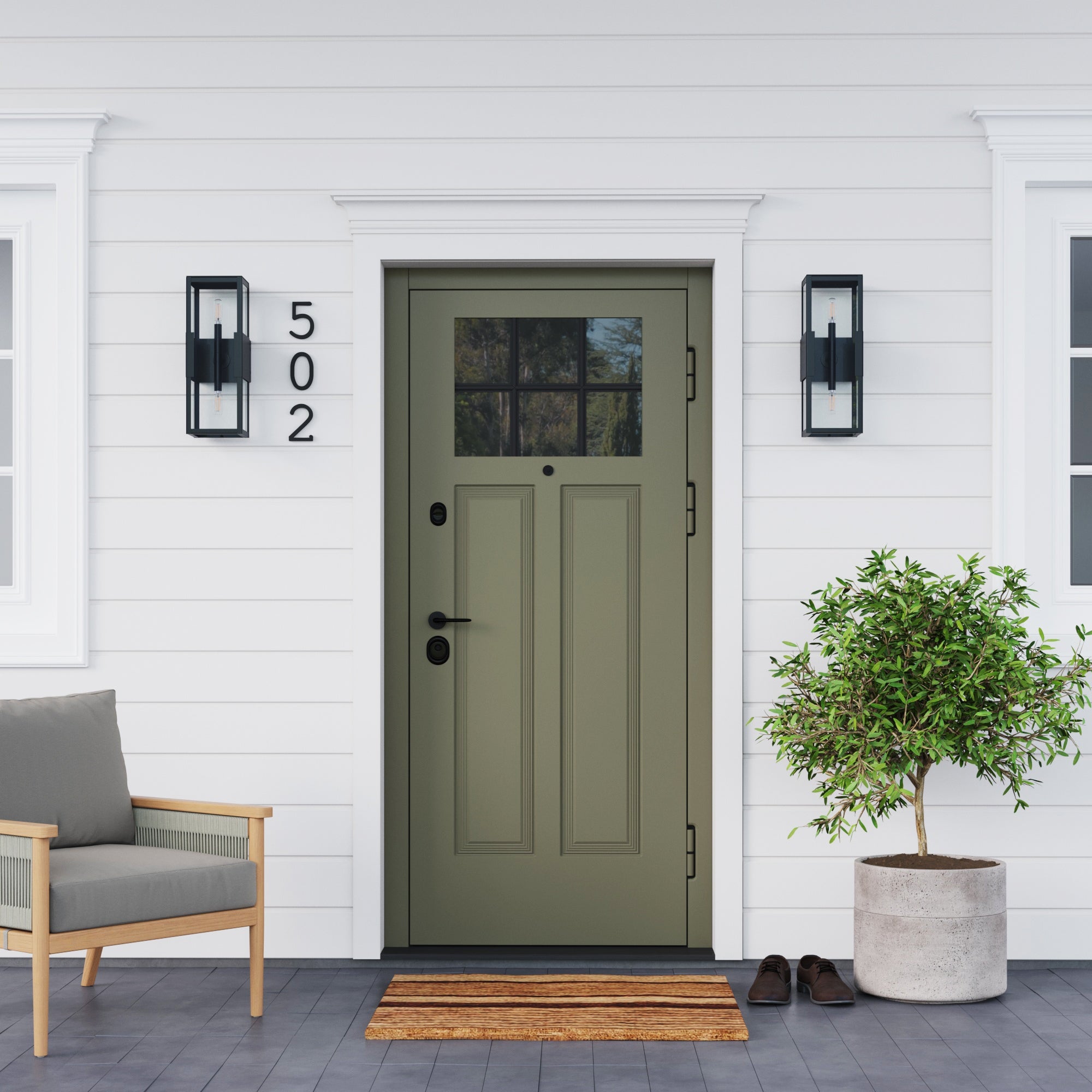 A centered green front door with glass panes marks a white house with horizontal siding, flanked by Nathan James Modern Outdoor Glass 2-Bulb Wall Lights (set of 2). House number 502, a doormat, shoes, potted tree, and chair are also seen.