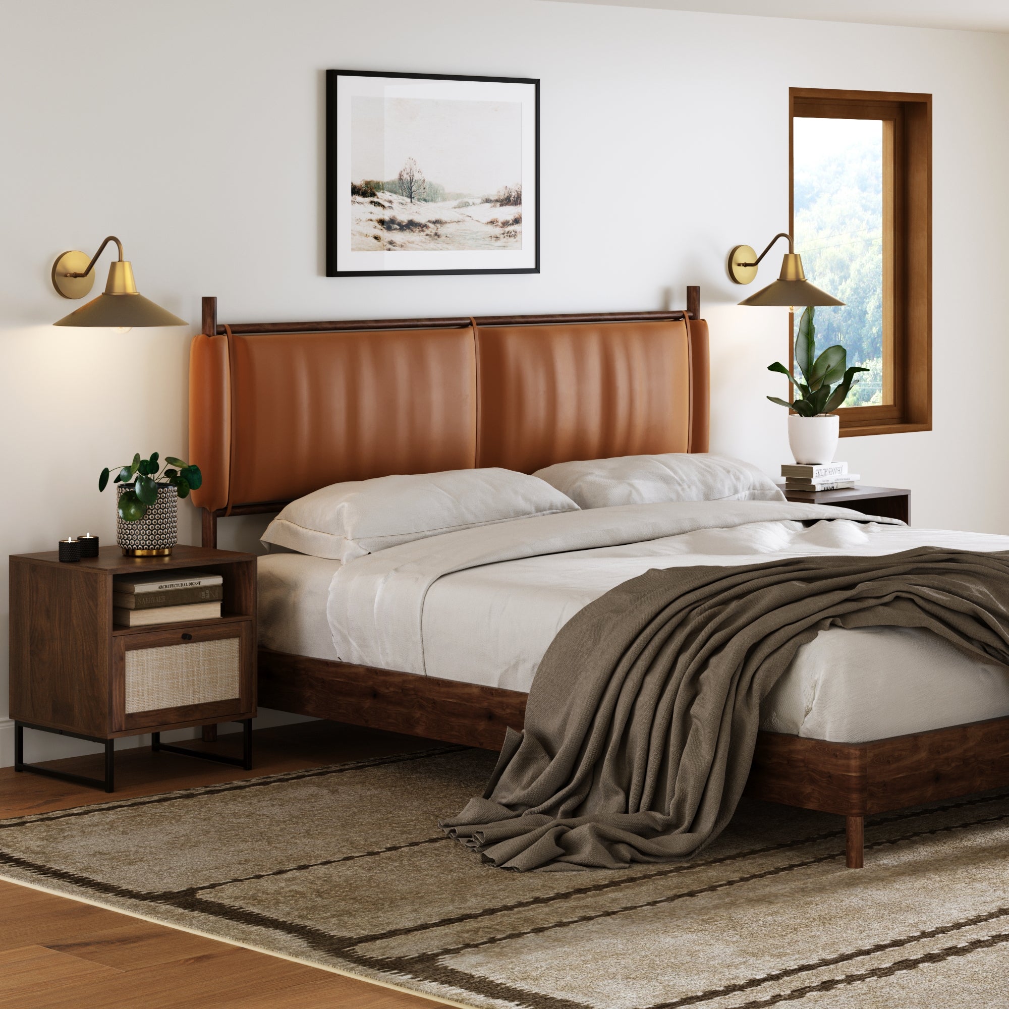 A modern bedroom features a brown leather headboard, gray blanket, wooden nightstands, framed landscape art, and a window with tree views. Above each nightstand is a Nathan James Mid-Century Modern Metal Vintaged Brass Wall Sconce (Set of 2).