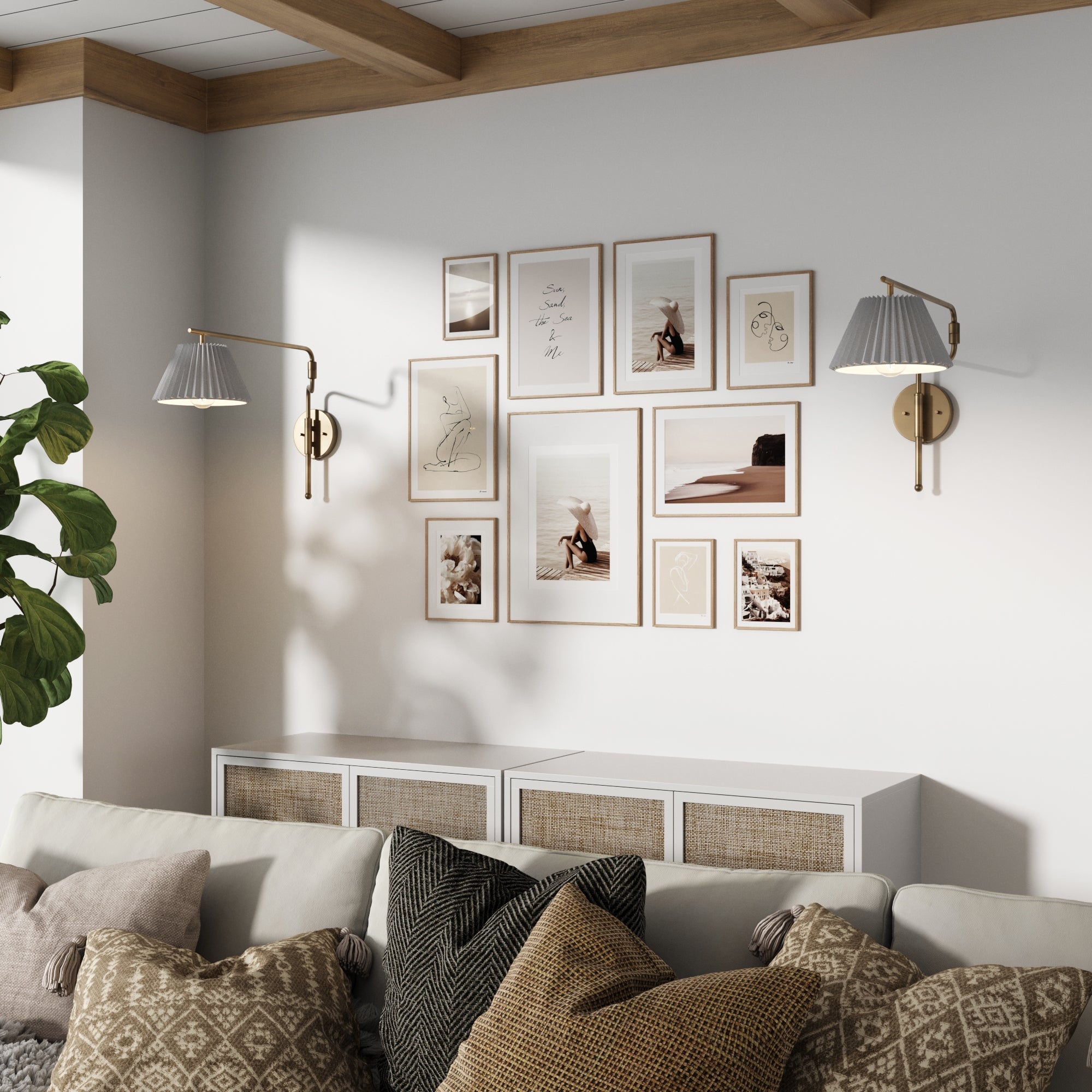 A cozy living room with a white sofa, patterned pillows, a plant, Nathan James Metal Swing Arm Wall Lights Brass (Set of 2) with white pleated fabric shades, and a gallery wall above a white cabinet.