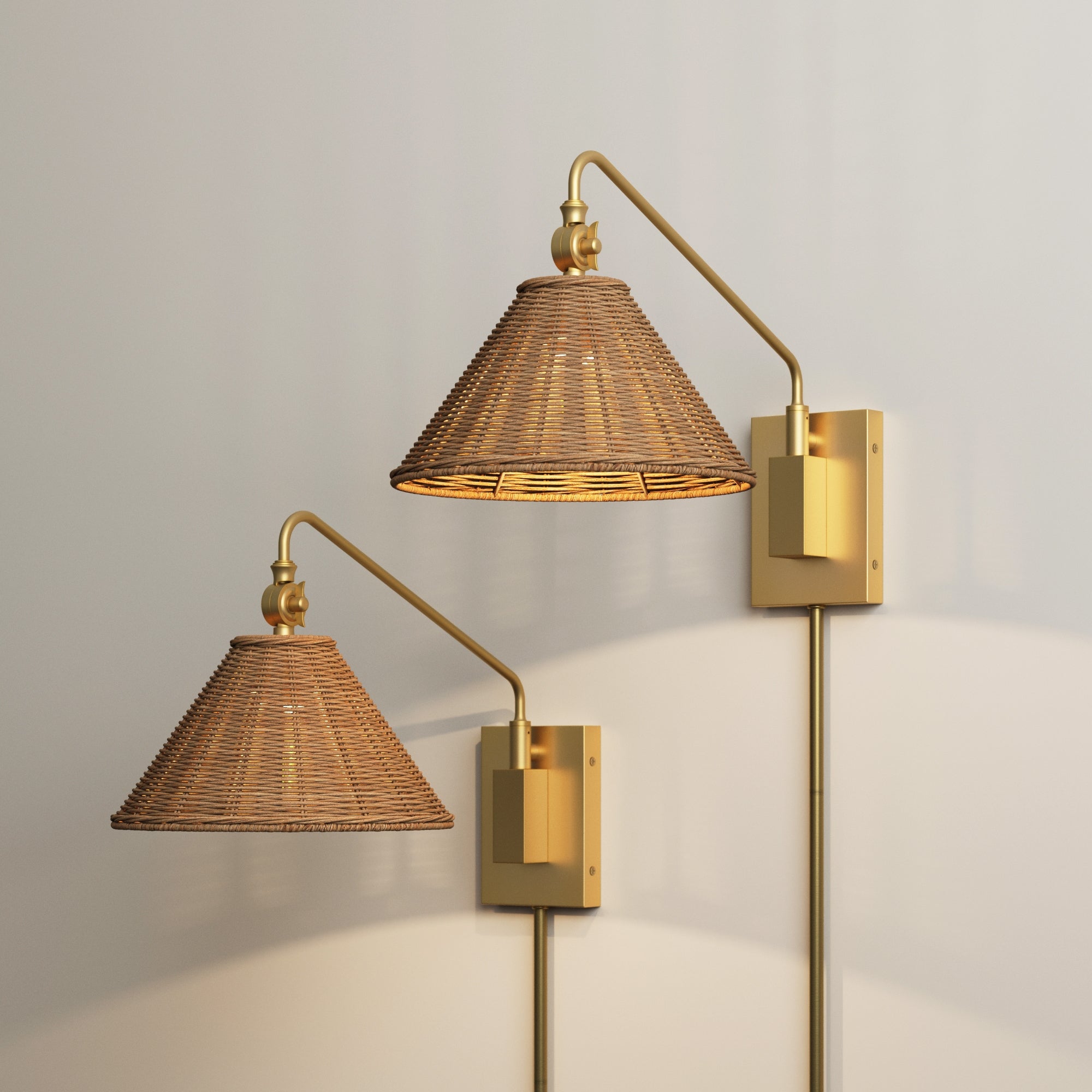 The Nathan James Rattan Shade Adjustable Plug In Wall Light (Set of 2) features woven shades, brass fixtures, and adjustable swing arms. Mounted on a light wall, these lamps provide warm modern farmhouse lighting with ambient glow.