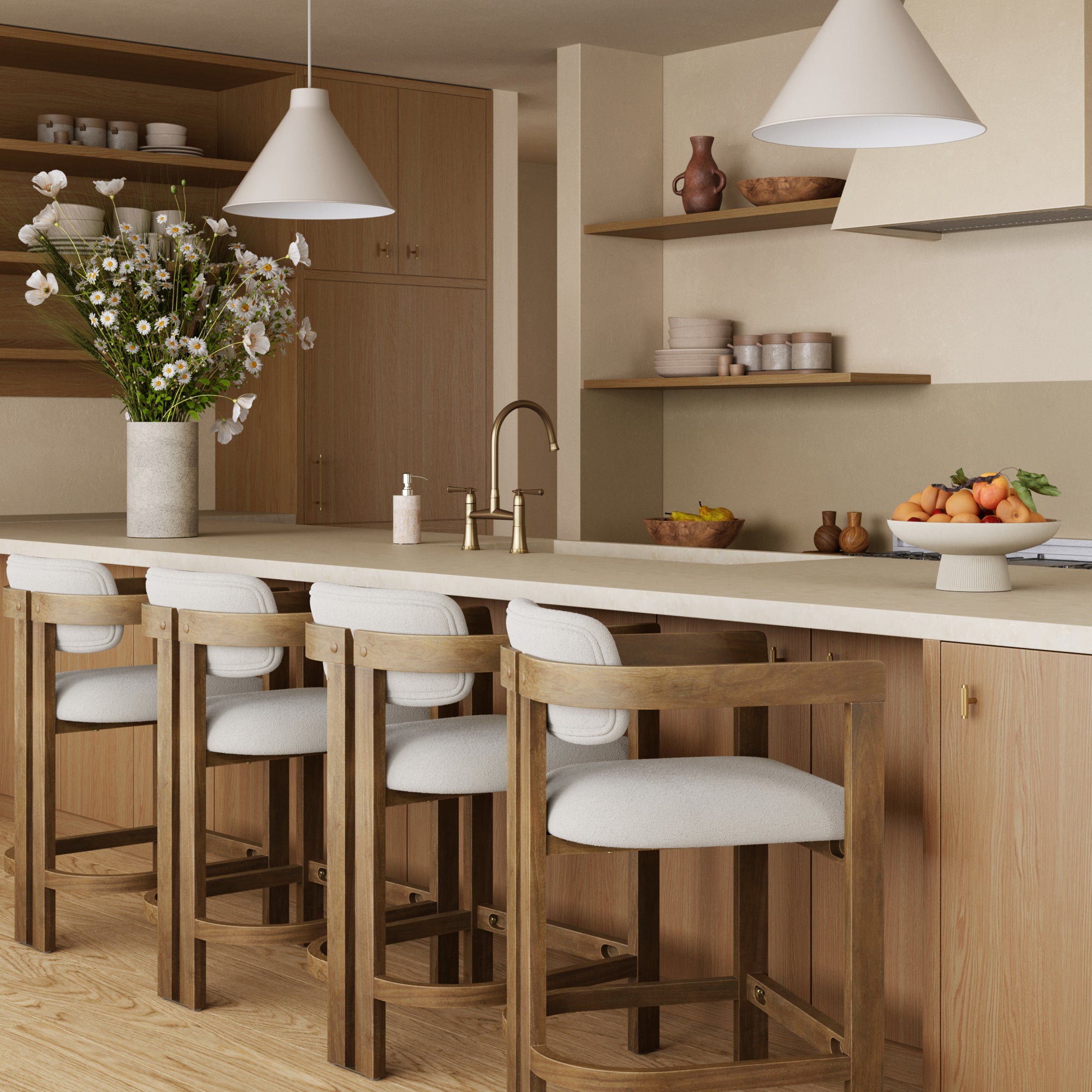 A modern kitchen with wooden cabinets, a long island featuring four Nathan James Barrel Bar Stool w/ Back and Arm in light brown, a vase of flowers, fruit bowl, open shelves displaying dishes and pottery, all lit by two pendant lights.