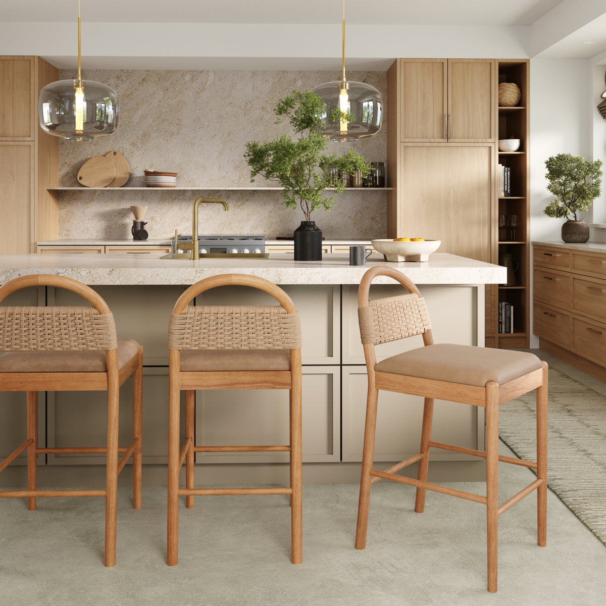 Three Nathan James Modern Seagrass & Faux Suede Counter Stool Warm Pine stools with seagrass backrests in a kitchen.