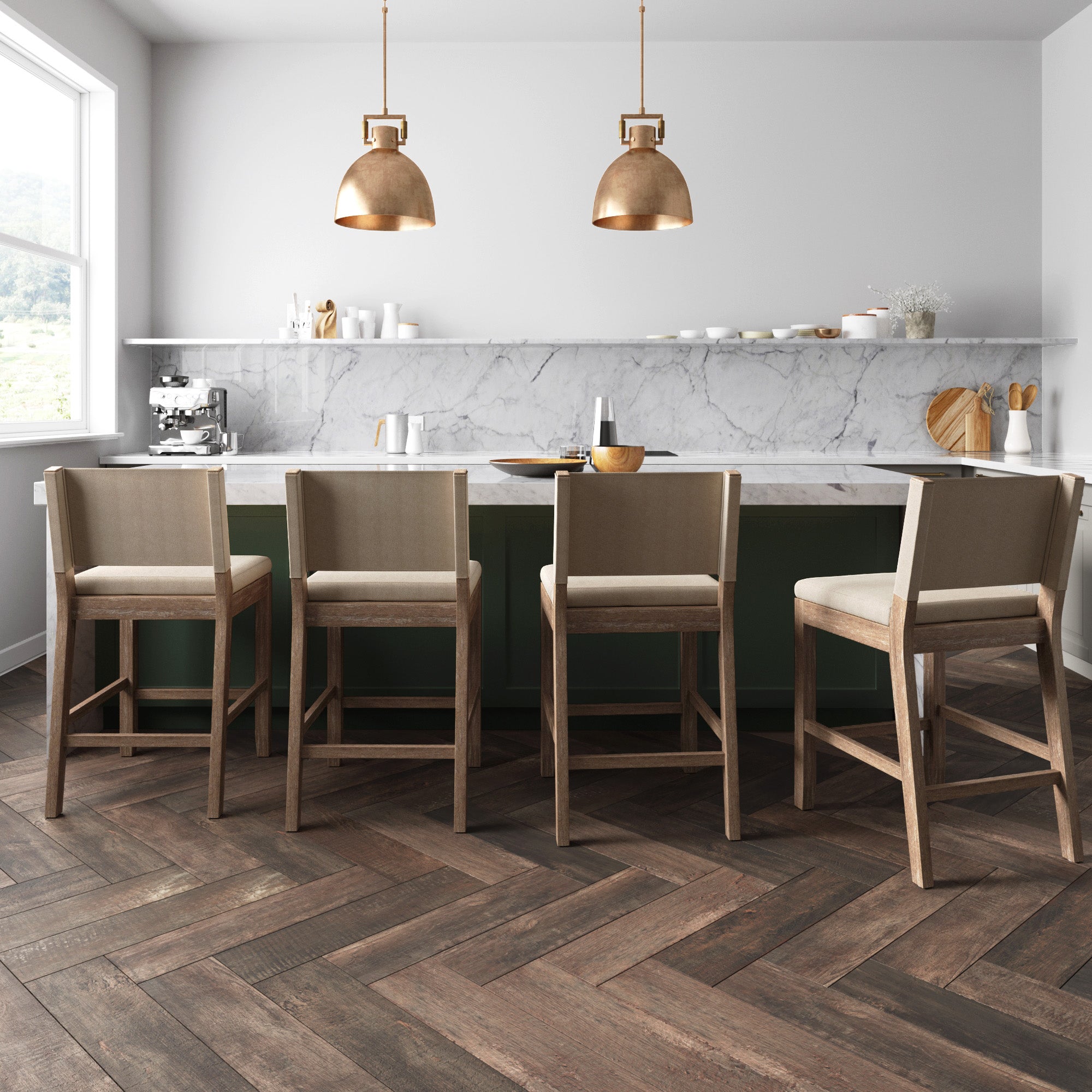 Modern kitchen with a marble backsplash, green island, four beige upholstered bar stools, two gold pendant lights, and herringbone-patterned dark wood floors. Shelves with dishes and a coffee machine are visible.