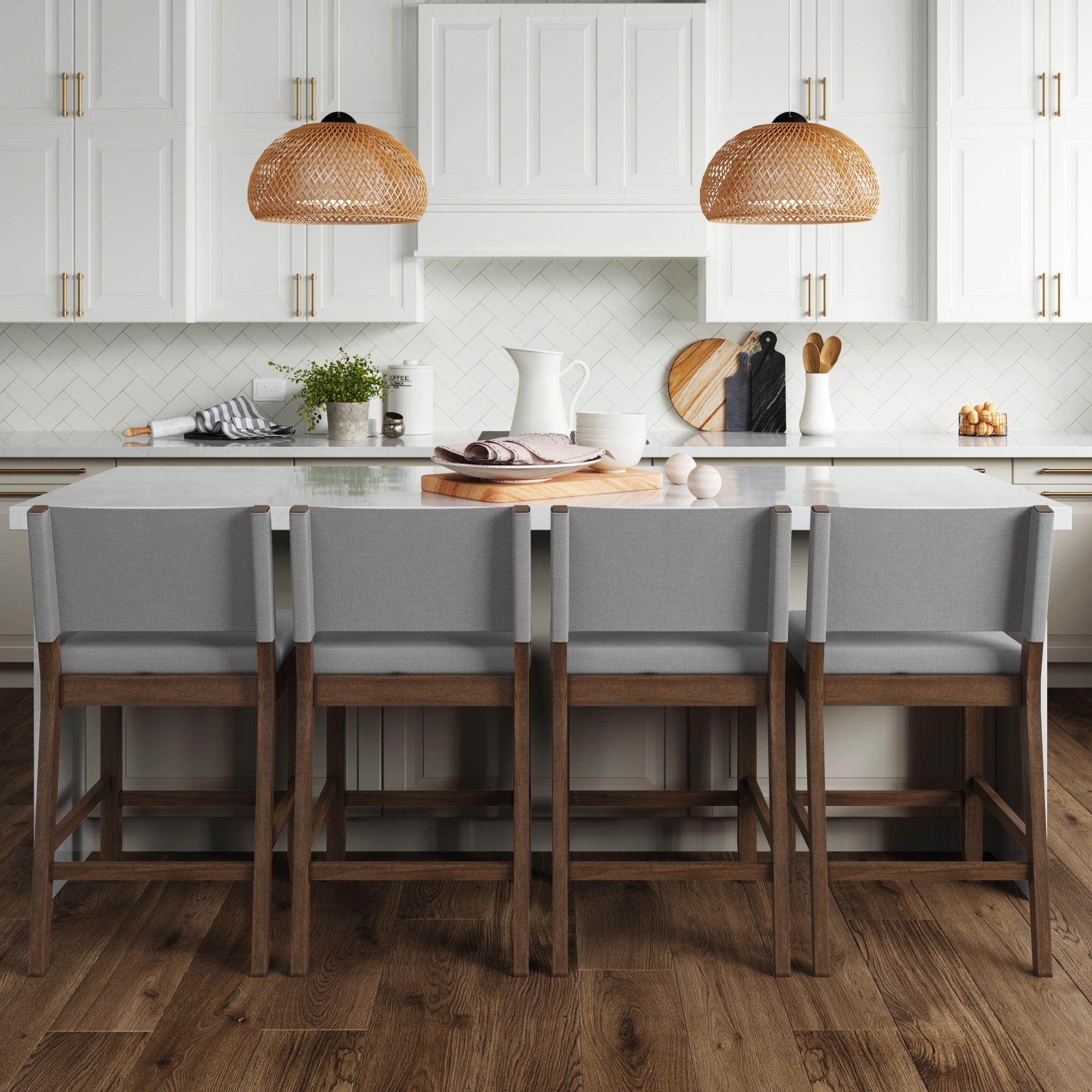 A modern kitchen with a large white island, set of 4 Nathan James Wood Counter Height Bar Stools in dark brown and gray, rattan pendant lights, white cabinets, wood floors, and modern farmhouse touches like plants and cutting boards.