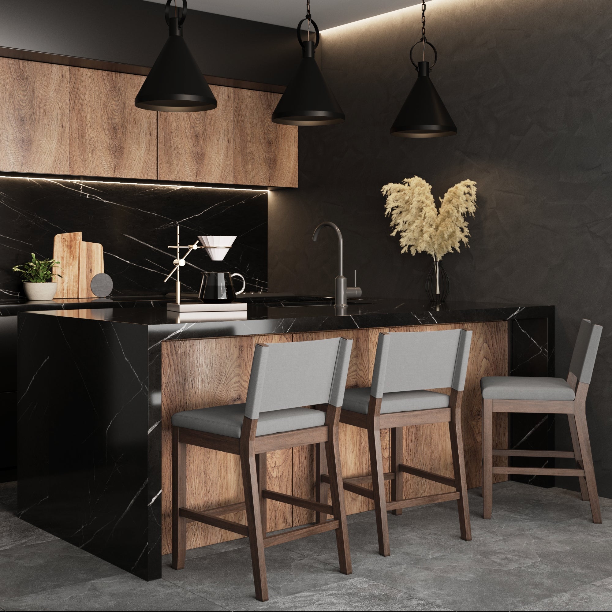 Modern kitchen with black marble countertops, wood cabinetry, and three Nathan James Wood Counter Height Bar Stools in dark brown and gray. Pendant lights and beige pampas grass add warmth to the sleek, minimalist space with modern farmhouse accents.