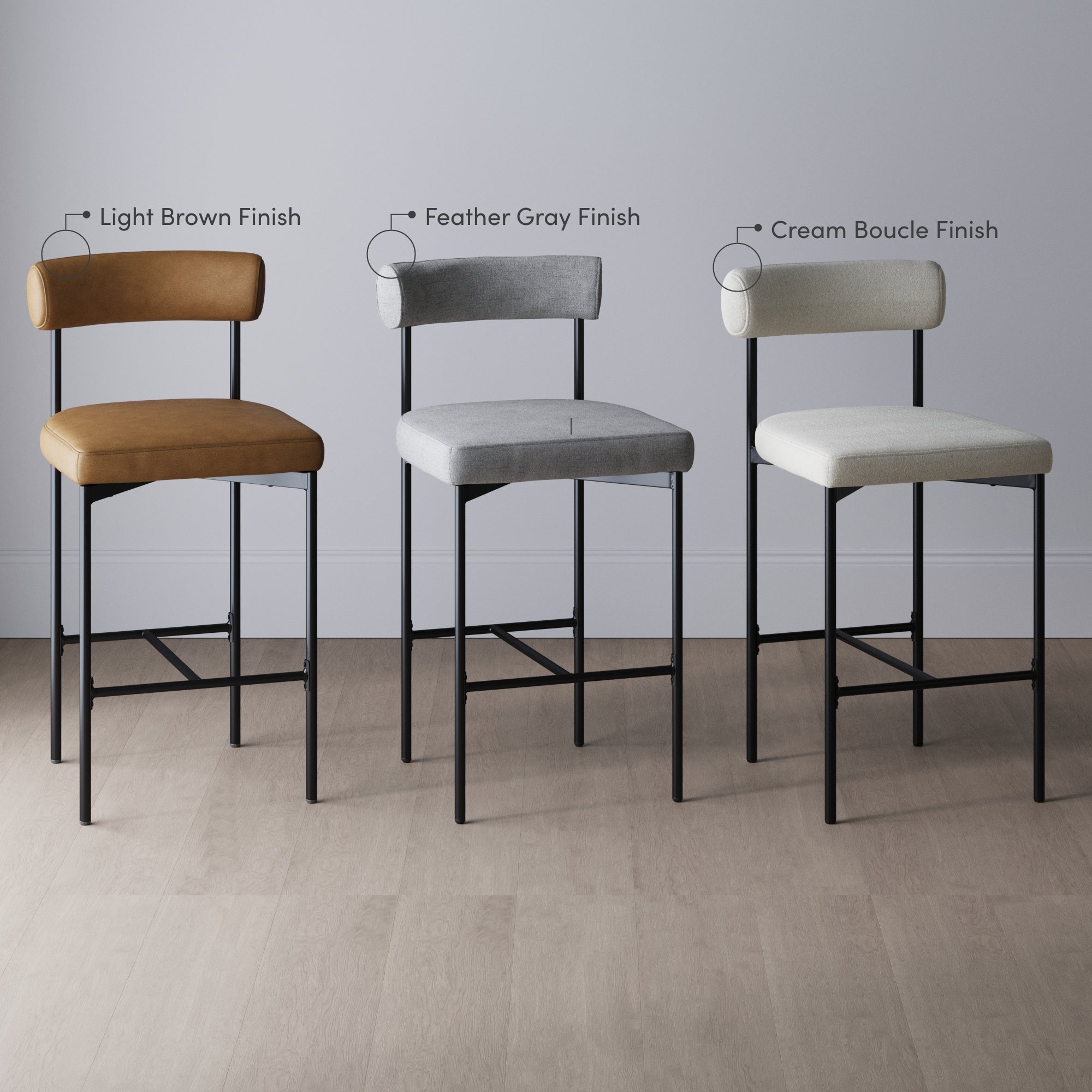 Three bar stools with metal legs are lined up side by side against a wall, each with different upholstery: light brown, feather gray, and cream boucle finishes labeled above the corresponding stools.