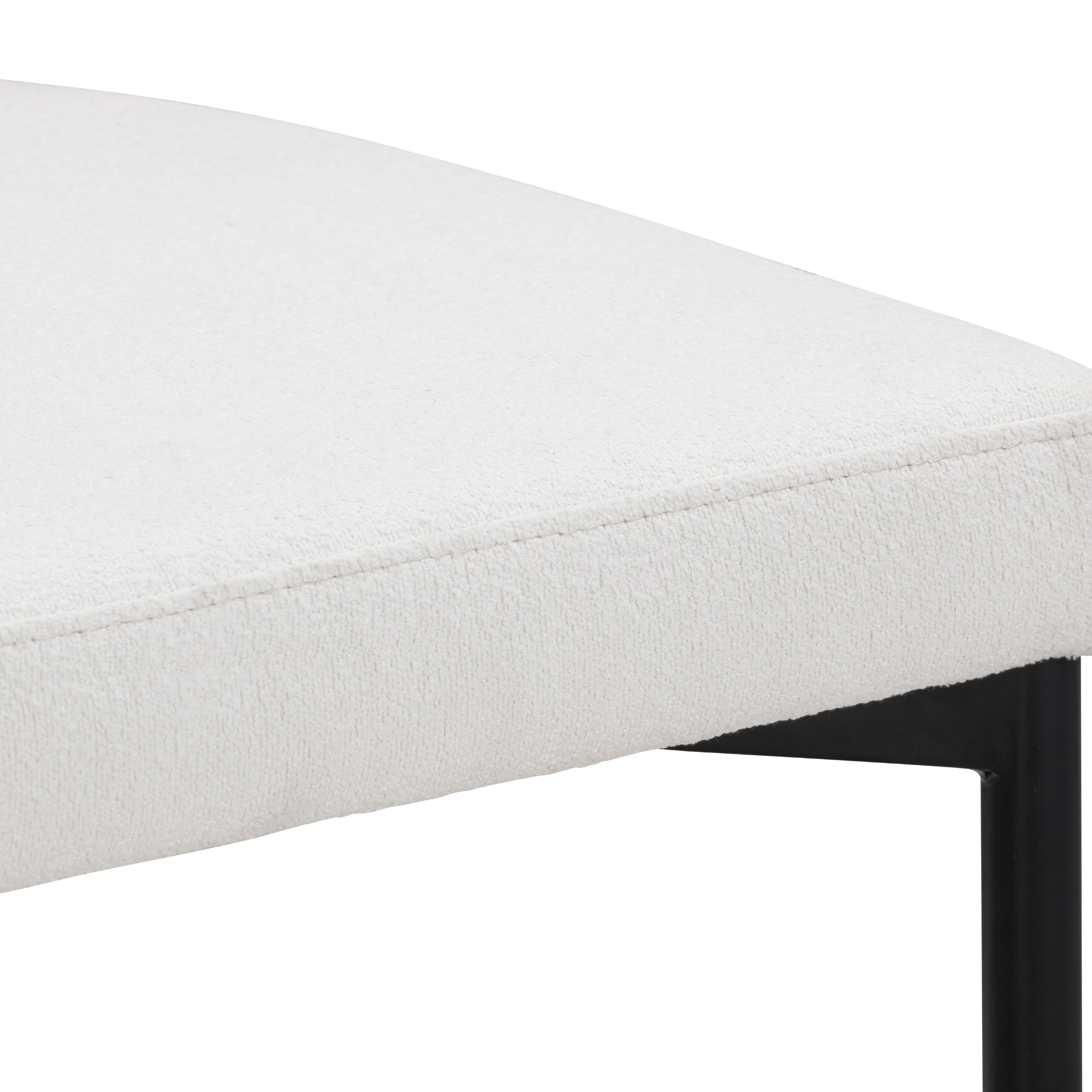 Close-up of the corner of a white, upholstered seat cushion with a soft texture, supported by a black metal frame.