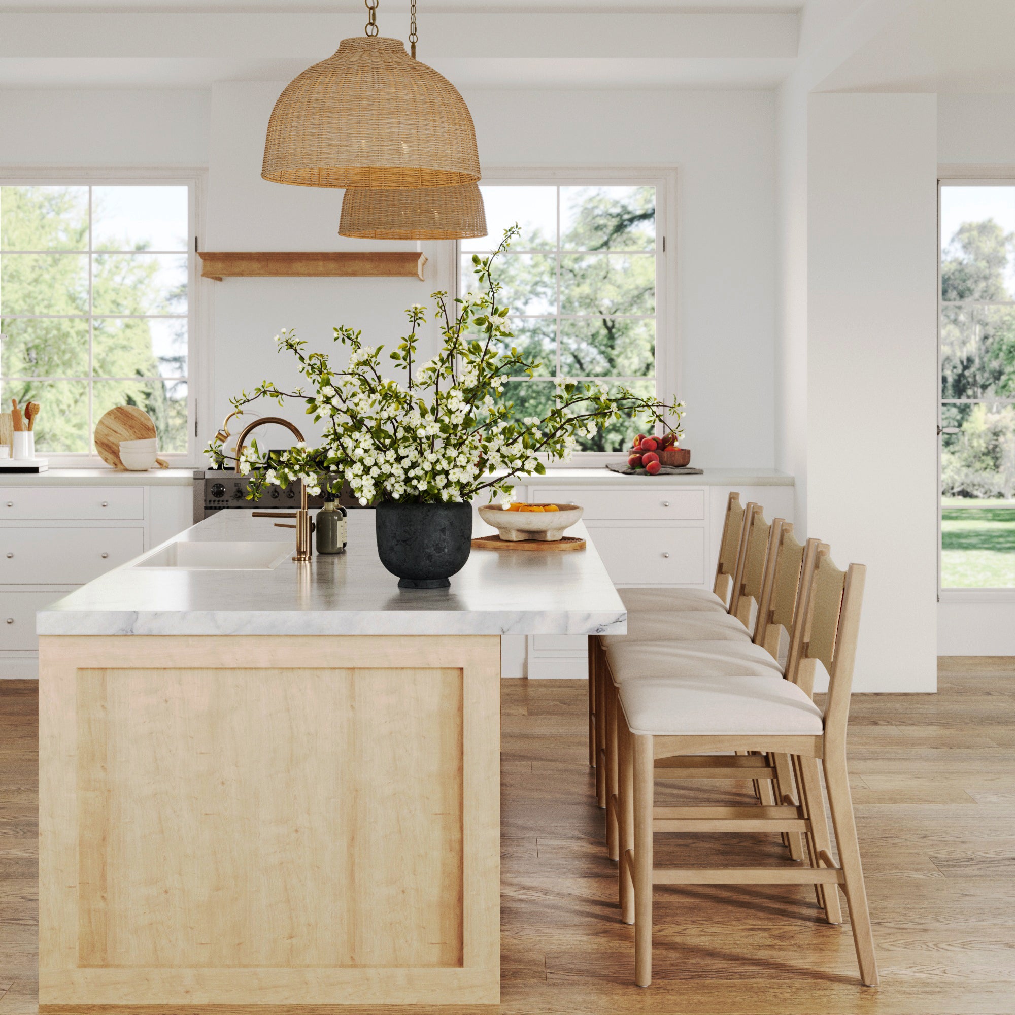 Bright, modern kitchen with large windows, a light wood island, marble countertop, and Nathan James Seagrass Back Arched Footrest Counter Height Bar Stools (Set of 4). A black vase with white flowers sits under two woven pendant lights.