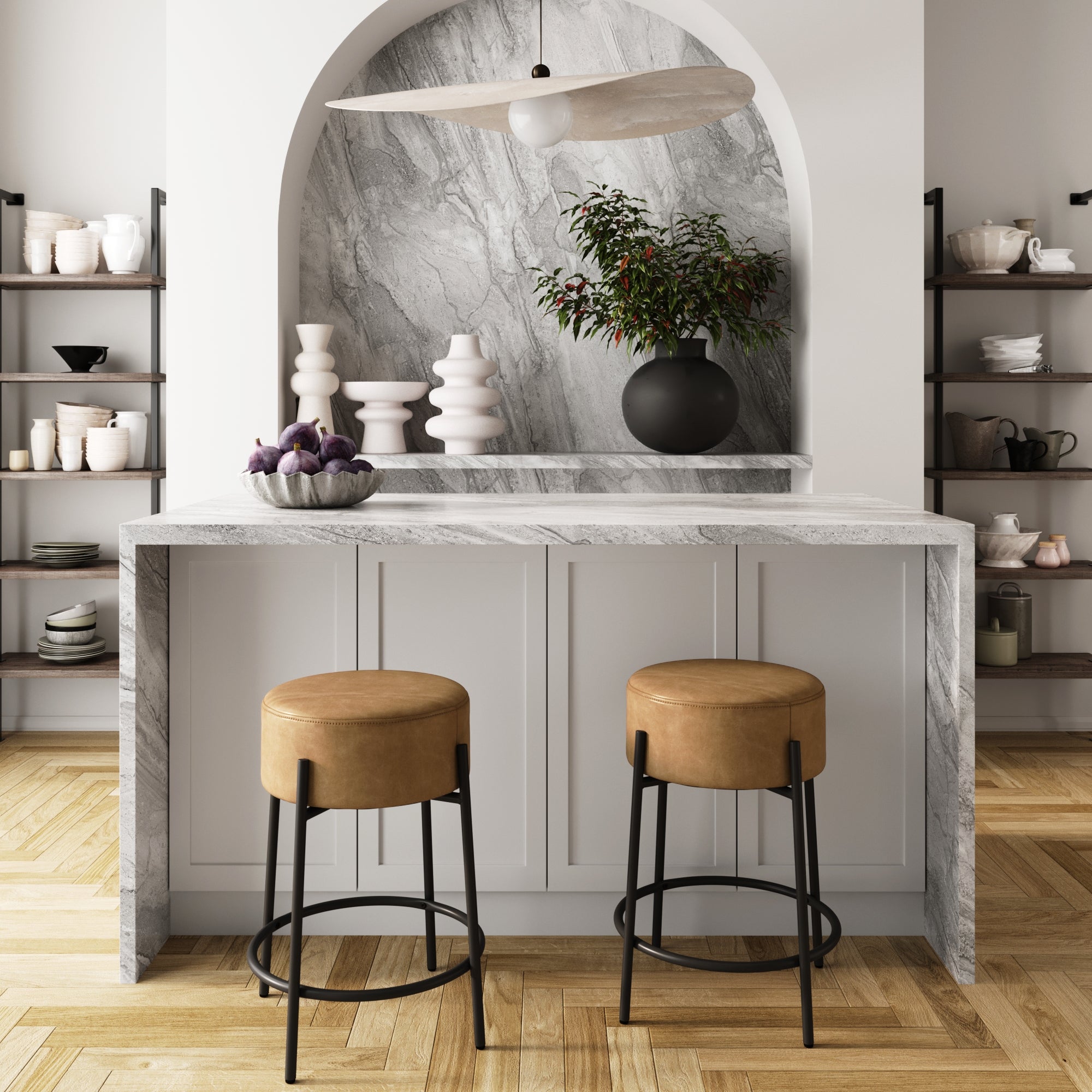 Modern kitchen with a marble island, Nathan James Round Faux Leather Backless Counter Height Bar Stools in brown (set of 2), decorative vases including a black vase with greenery, open shelving with dishes, and a large pendant light overhead.