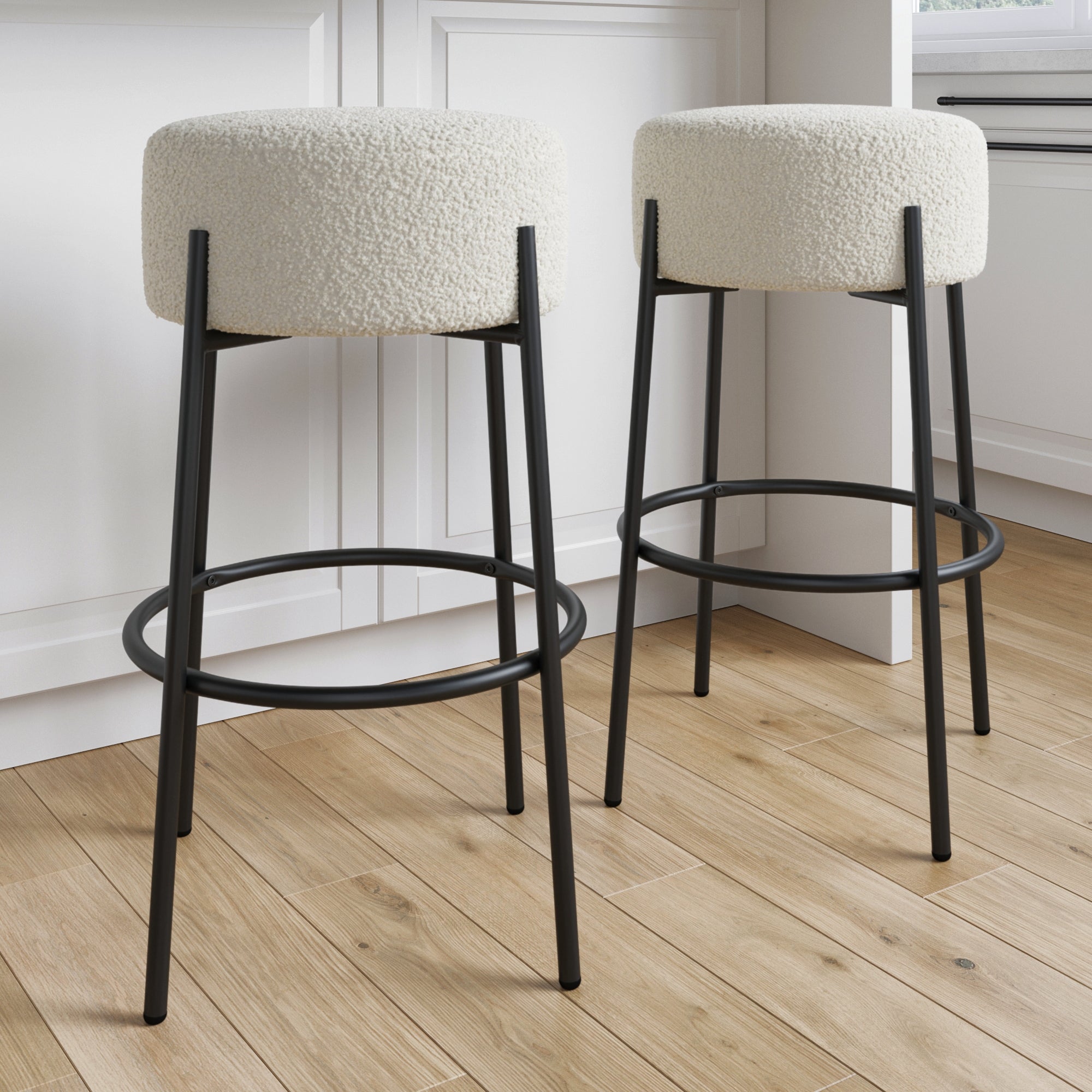 The Nathan James Round Boucle Backless Bar Stools (Set of 2) feature cream textured seats and black metal legs, ideal for use as stylish kitchen island stools.