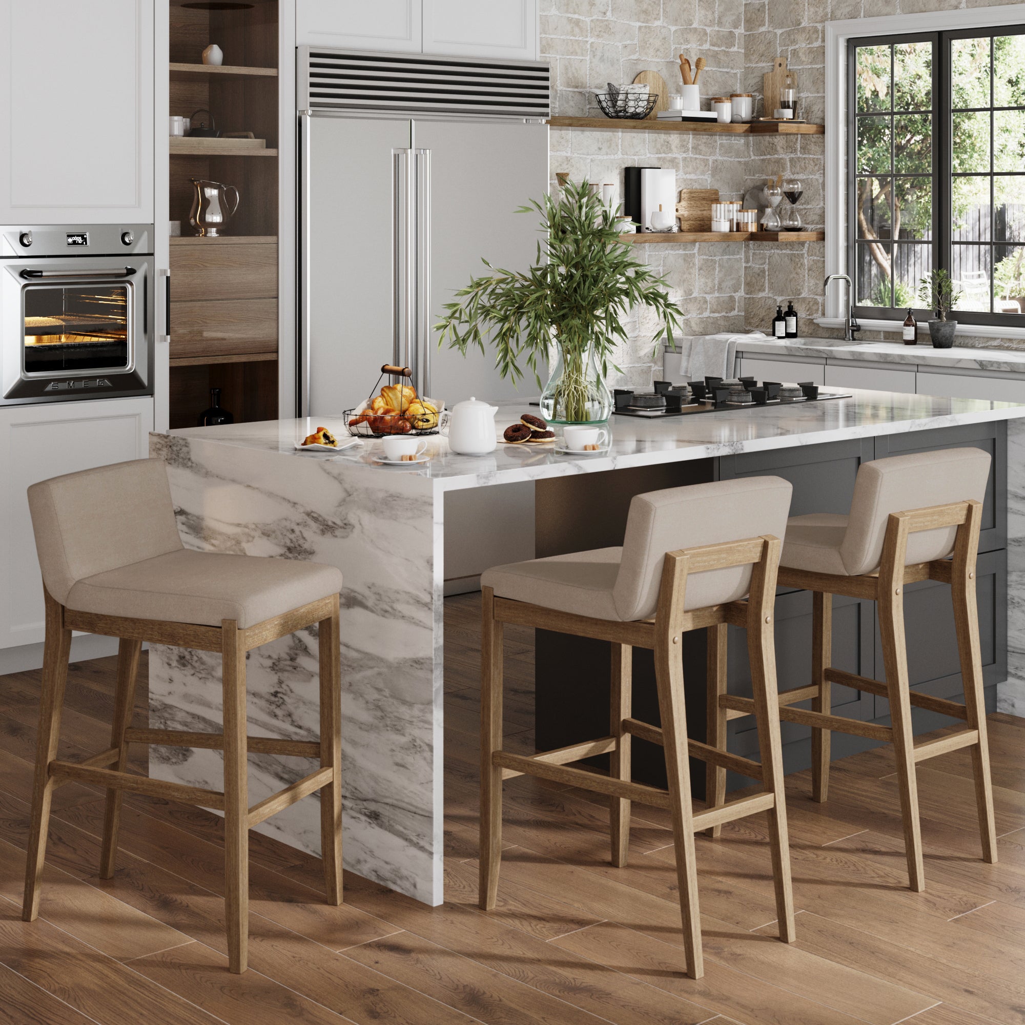 Modern kitchen with a marble island, set of three Nathan James Exposed Wood Back Bar Stools in brown, built-in oven, stainless steel fridge, island cooktop, potted plant, large sunlit window, wood-paneled floor, and food and drinks on the counter.