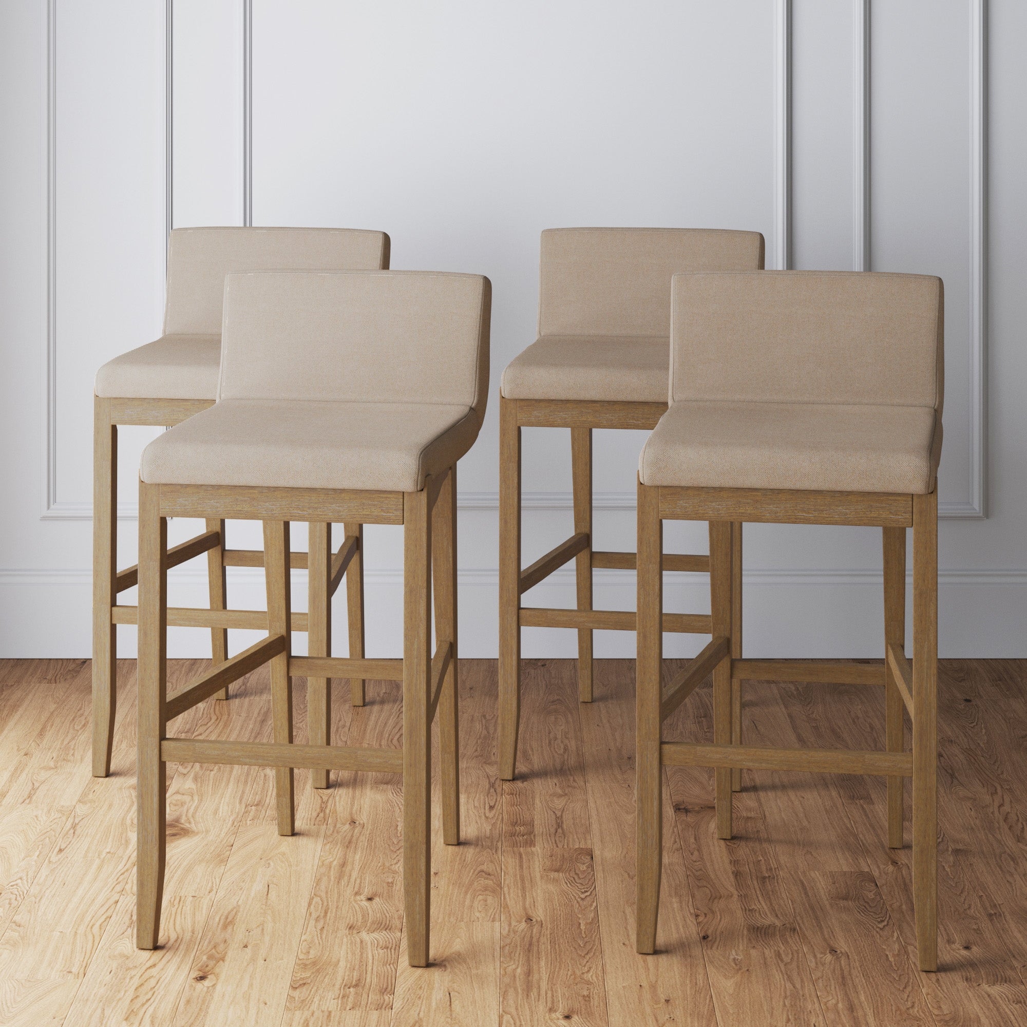 Four Exposed Wood Back Bar Stools Brown (Set of 4) by Nathan James are arranged in two rows on a wooden floor, set against a white paneled wall.