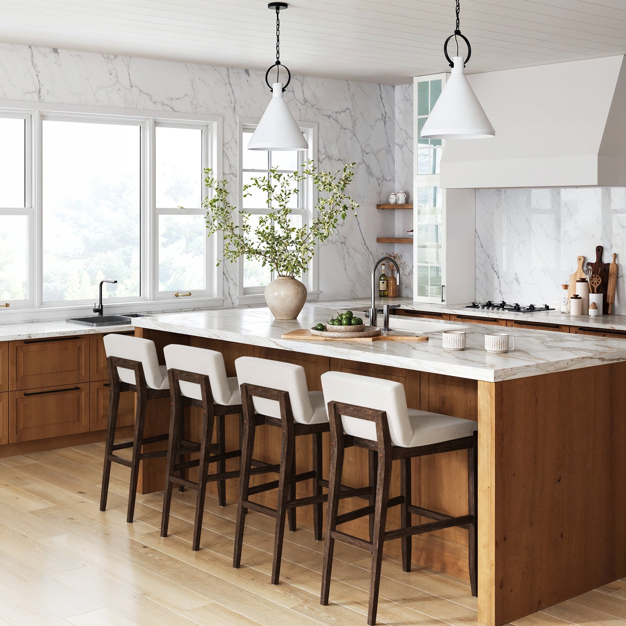 Modern kitchen with wooden cabinets, marble island and countertops, Nathan James Exposed Wood Back Bar Stools in dark brown (set of 4), pendant lights, a large vase with branches, and big windows for natural light.
