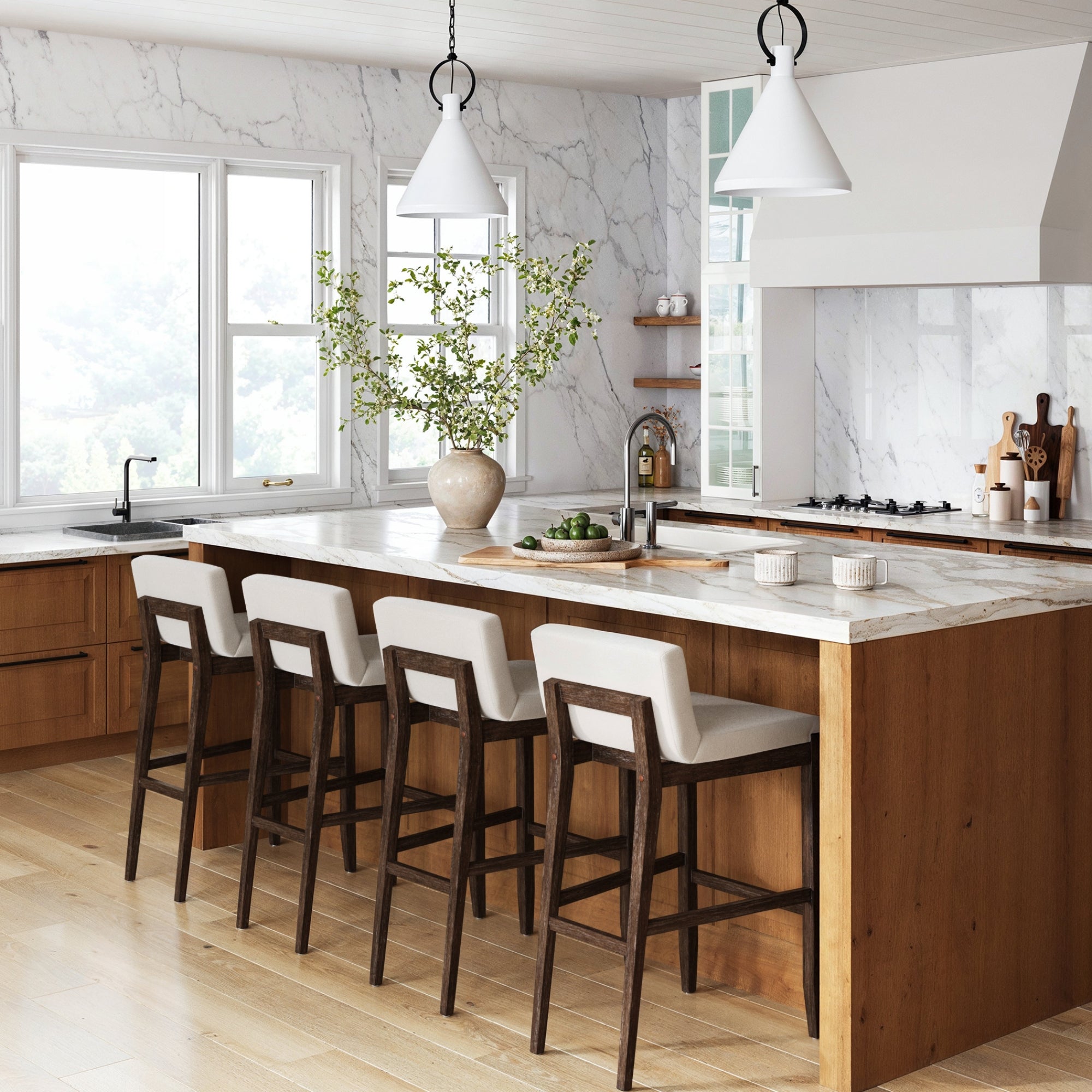 Modern kitchen with large marble island, four Nathan James Exposed Wood Back Bar Stools in dark brown, wooden cabinetry, pendant lights, vase with greenery, and built-in stove. Sunlight streams through large windows for a bright feel.