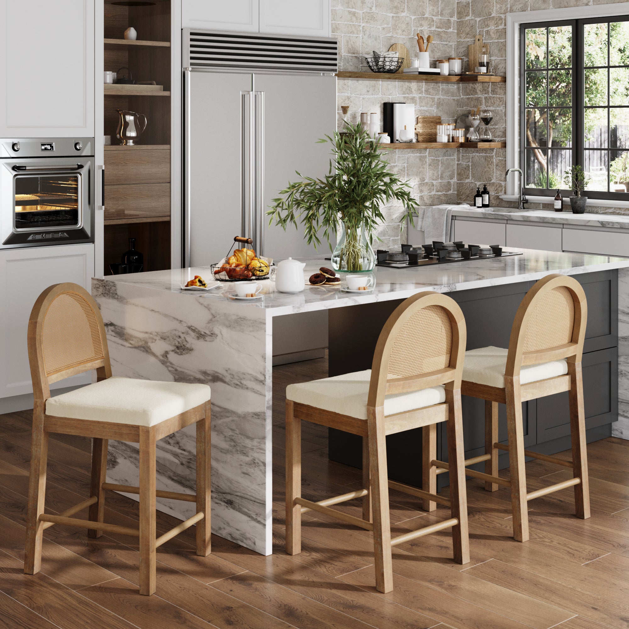 Modern kitchen with light wood floors, marble island, and three Nathan James Boucle & Rattan Counter Height Bar Stools in Light Brown. Features built-in appliances, open shelving, a vase of greenery on the island, and large window for natural light.