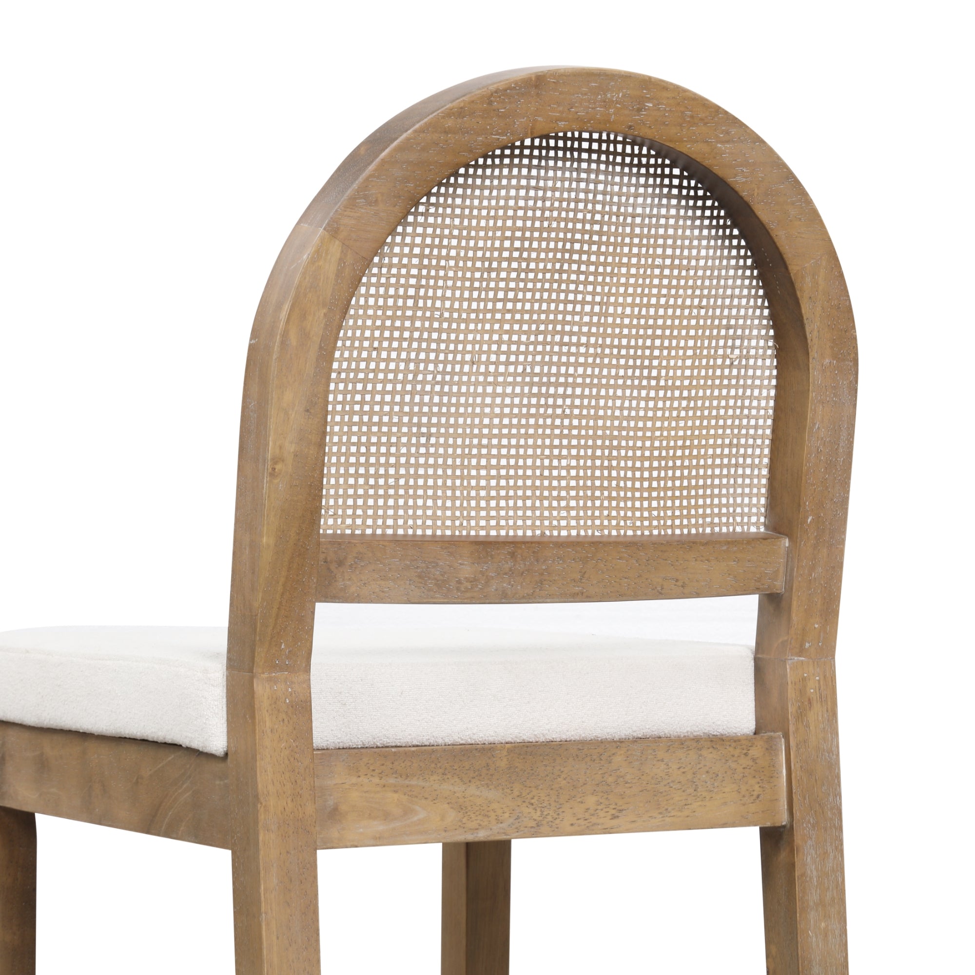 A wooden chair with a rounded backrest that features a woven cane panel and a cushioned white seat. The image shows a close-up view from the back and side.