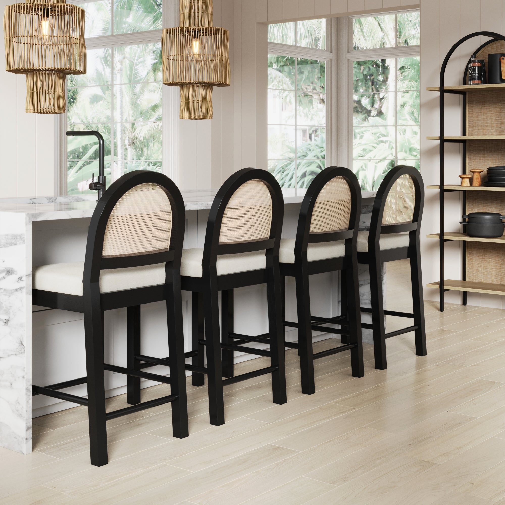 Four Nathan James Boucle & Rattan Counter Height Bar Stools in black (set of 4) with cushioned seats are placed at a marble kitchen island, beneath pendant lights and beside large windows with a lush outdoor view and shelves of dishes.