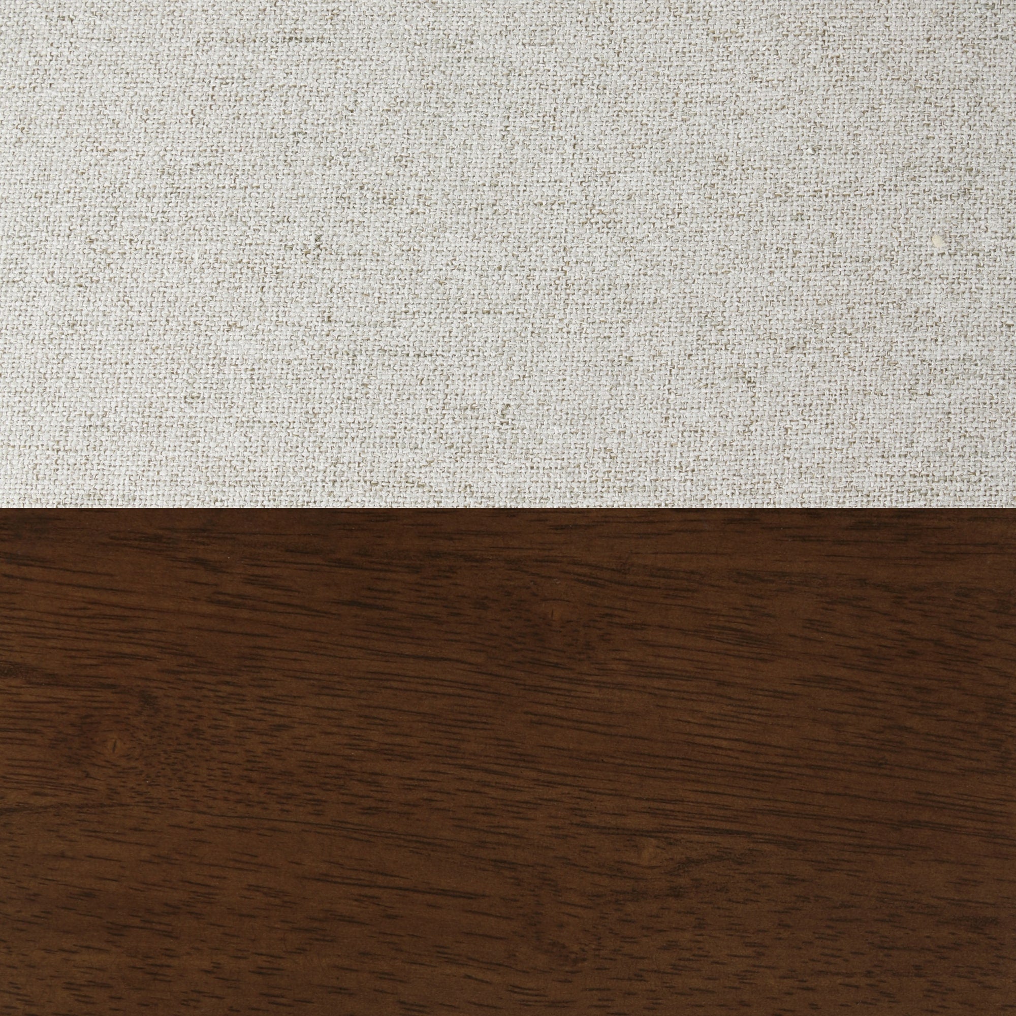 A textured white fabric and a smooth dark brown wood surface meet horizontally, creating a simple, minimalistic contrast between the two materials.