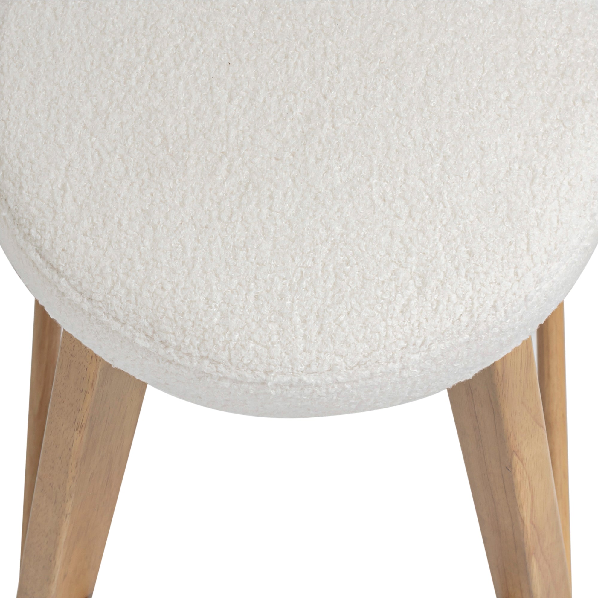 Close-up of a round, white, textured fabric seat with light wood legs on a chair, viewed from above.