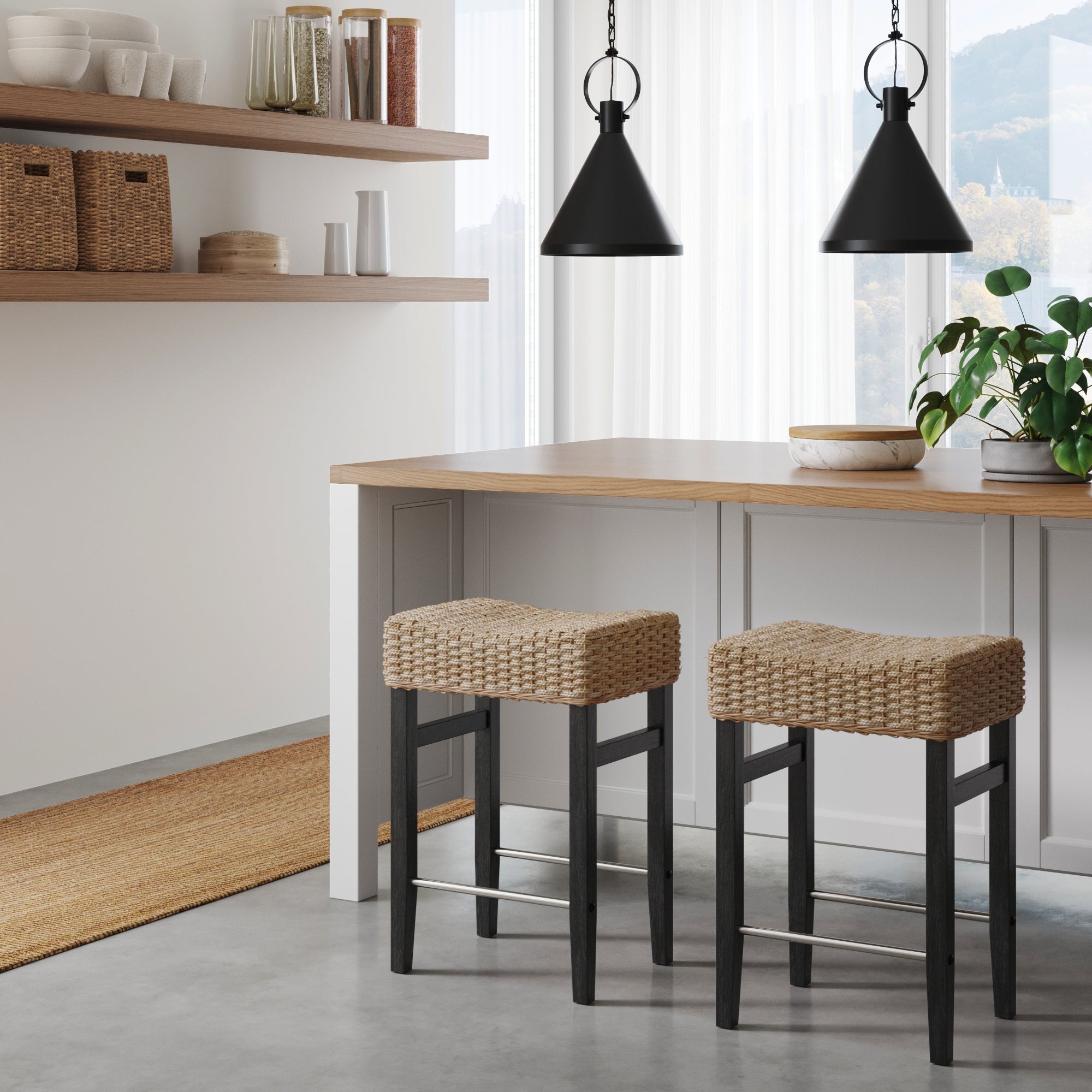 Modern kitchen with a wooden island, two Nathan James Seagrass Counter Height Bar Stools in black, pendant lights, open shelves with baskets and jars, a plant, and large windows letting in natural light.