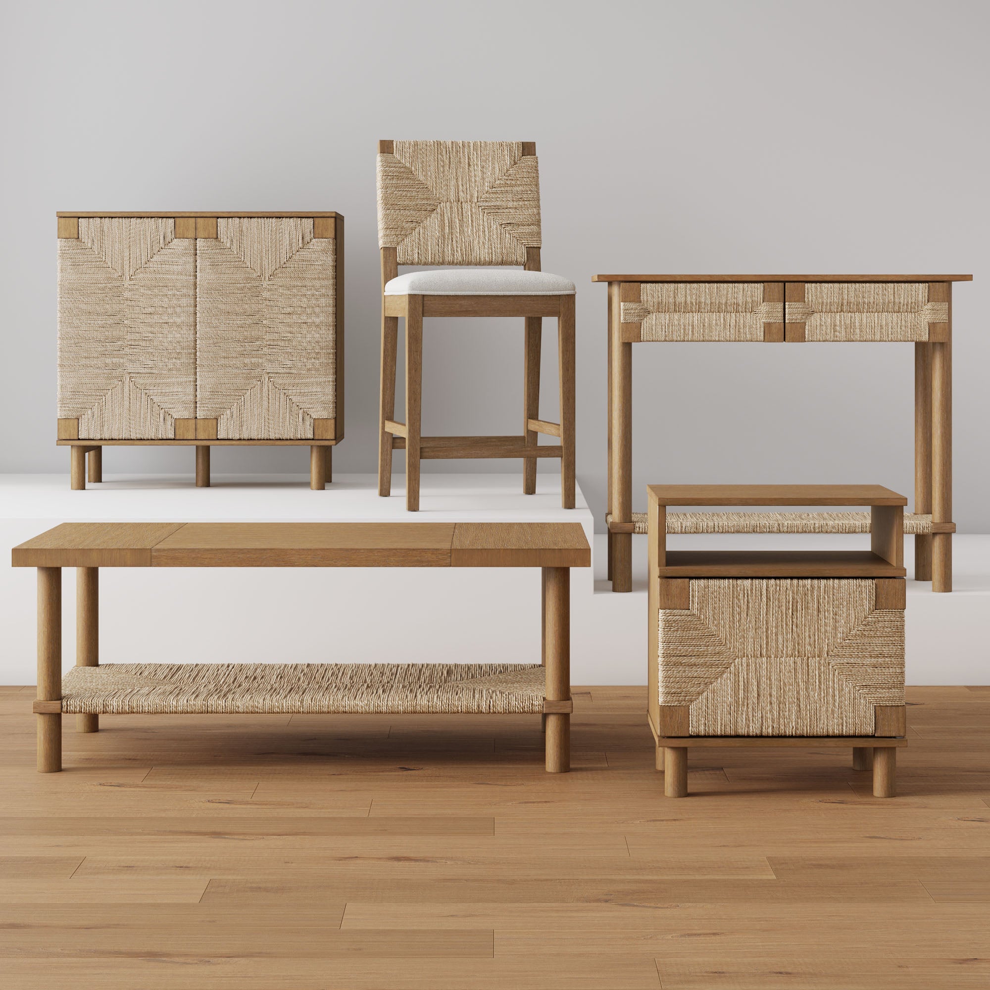 Five pieces of wooden furniture with woven rattan details are arranged in a row on a wood floor, including a cabinet, chair, desk, coffee table, and nightstand, against a plain light gray wall.