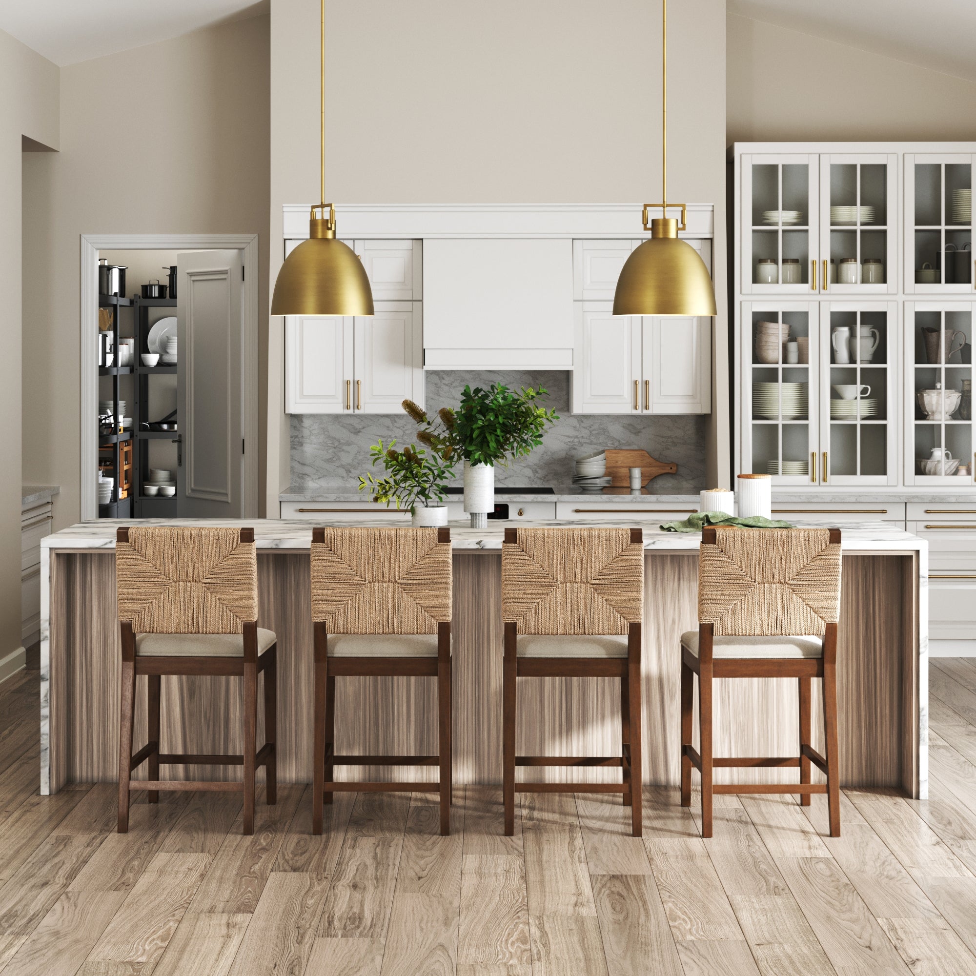 Modern kitchen with a large island, four Nathan James Seagrass Counter Height Bar Stools in dark brown, two gold pendant lights, light wood floors, white cabinetry, a visible pantry, and greenery on the marble countertop.