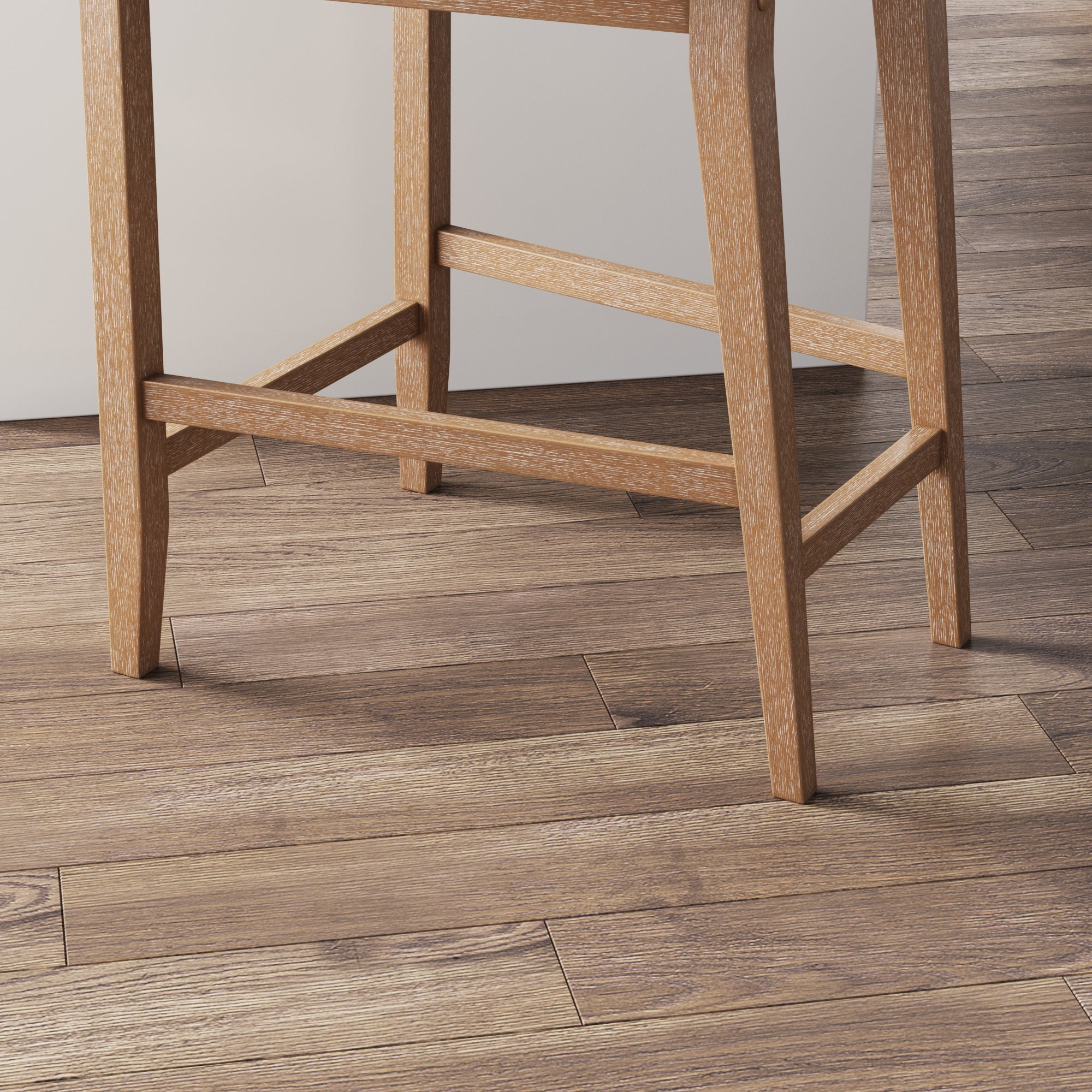 A close-up view of the legs of a wooden chair on a floor with wood-textured laminate or hardwood planks in varying shades of brown.