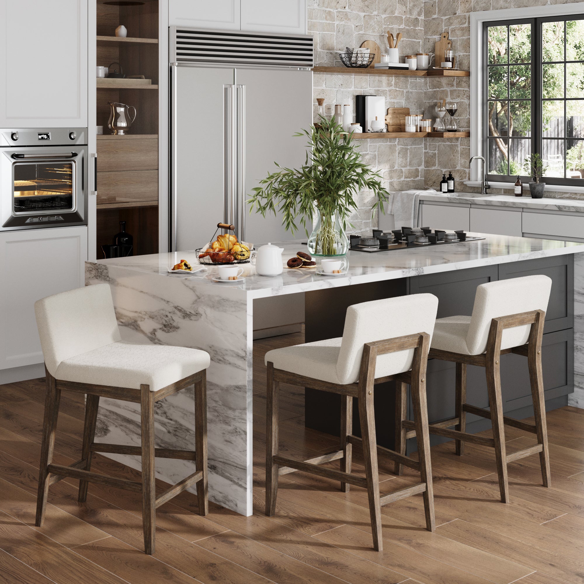 Modern kitchen with a marble island, set of 3 Nathan James Boucle Counter Height Bar Stools in dark brown, built-in appliances, wooden floors, open shelving, large windows, a vase with greenery, plus pastries, tea, and fruit on the counter.