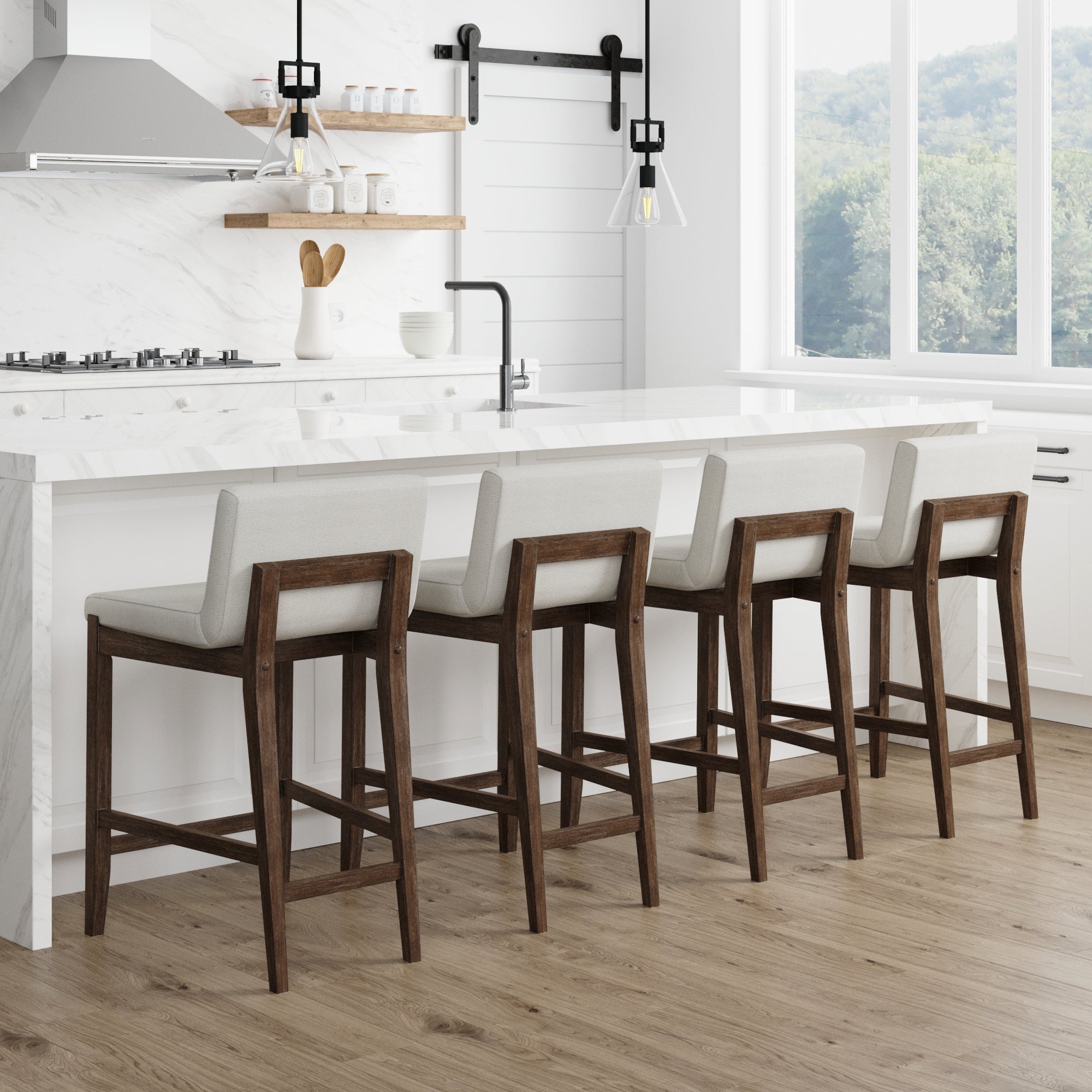 A modern kitchen with a white marble island, four Nathan James Boucle Counter Height Bar Stools in dark brown, a gas stove, floating shelves, pendant light, and a large window overlooking greenery.