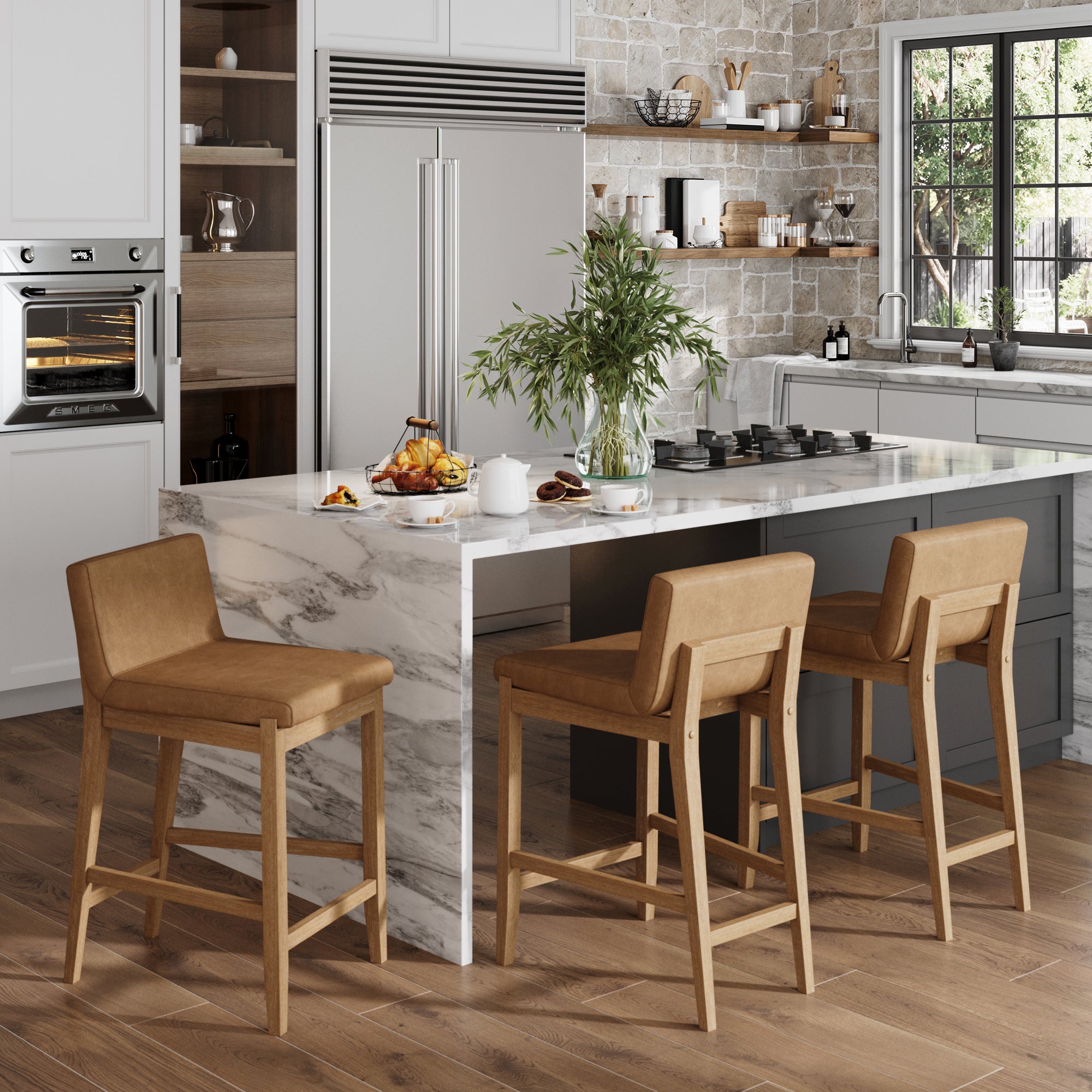 Modern kitchen with light wood floors, a marble island featuring three Nathan James Faux Leather Counter Height Bar Stools in light brown, stainless steel appliances, open shelving for dishes, and a large window with natural light.
