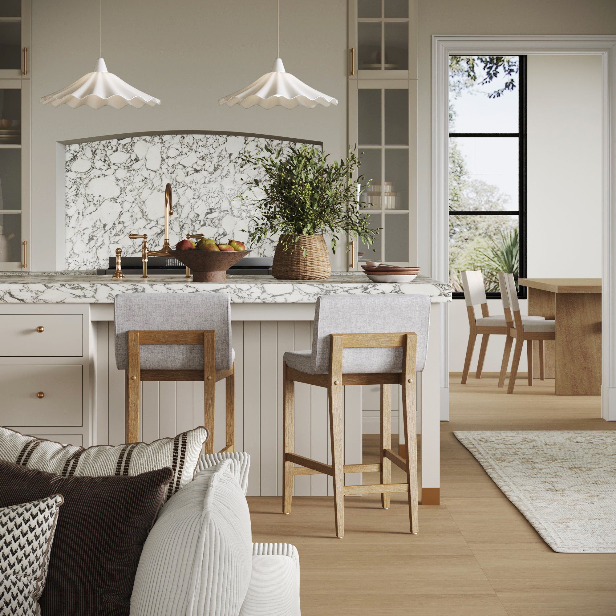 A modern kitchen with a marble backsplash and countertop, two Nathan James Upholstered Counter Height Bar Stools with gray backs, pendant lights above, plants on the counter, and a view of the dining area through a doorway.