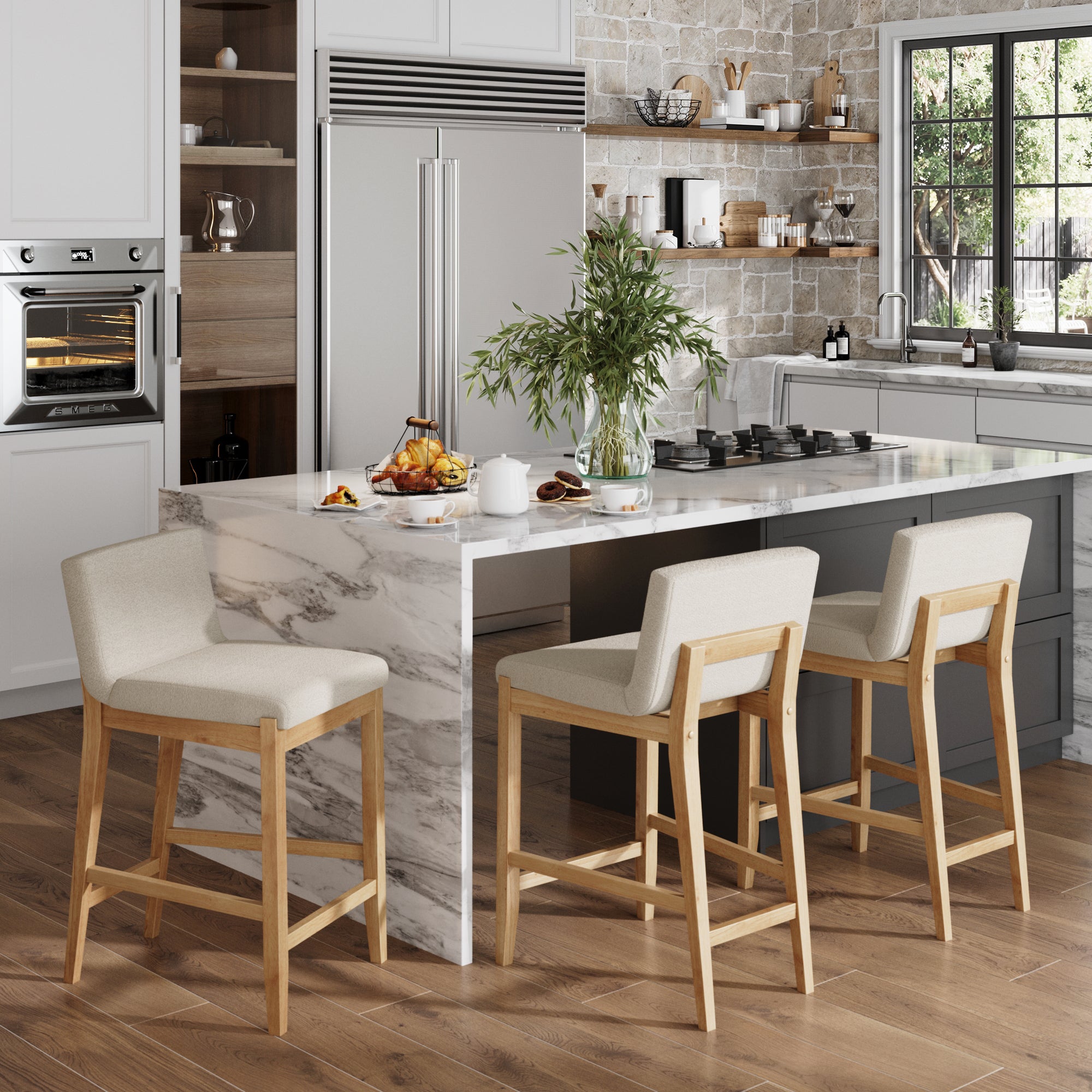 A modern kitchen with a marble island, Nathan James Boucle Counter Height Bar Stools in Warm Pine (set of 3), breakfast items on the counter, a potted plant, built-in appliances, and a large window letting in natural light.