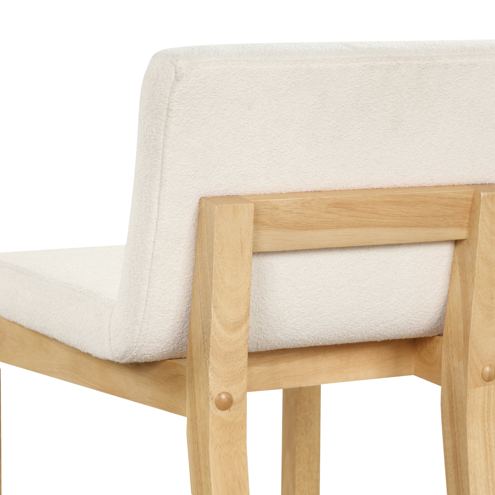 Close-up of the back and seat of a wooden chair with light-colored legs and a plush, white upholstered backrest and seat.
