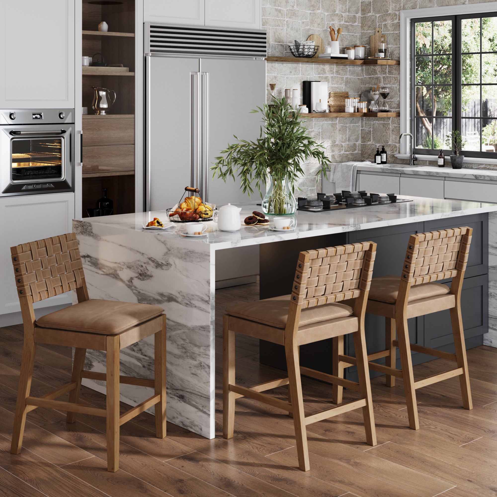 Modern kitchen featuring Nathan James Woven Counter Height Bar Stools in brown (set of 3) with solid wood frames, a marble island, vase of greenery, pastries and tea set on the counter. Stainless steel appliances and open shelving provide an airy feel.