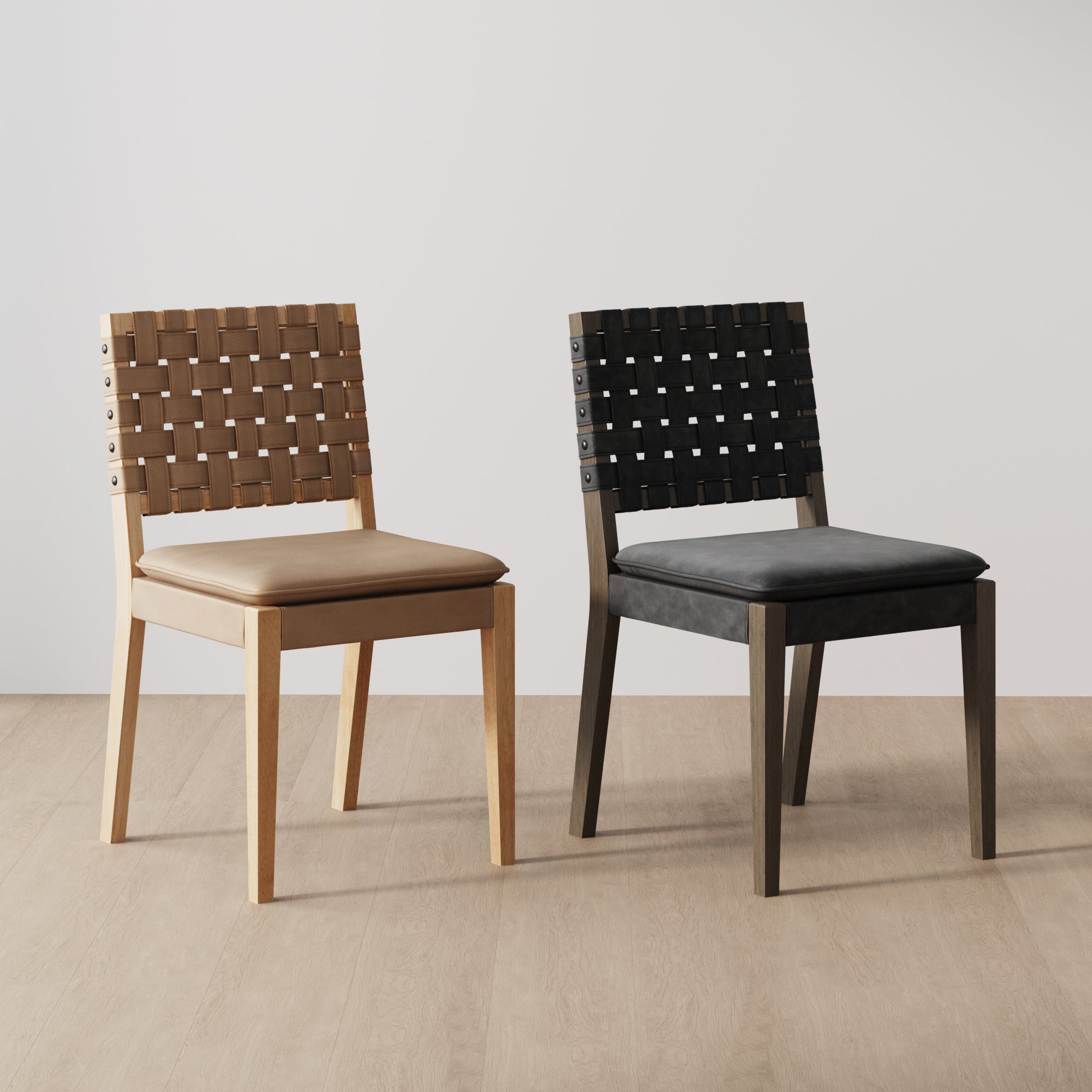 Two chairs with woven seats and backs, one in light wood with tan cushions, and the other in dark wood with black cushions, placed on a light wood floor against a plain white wall.