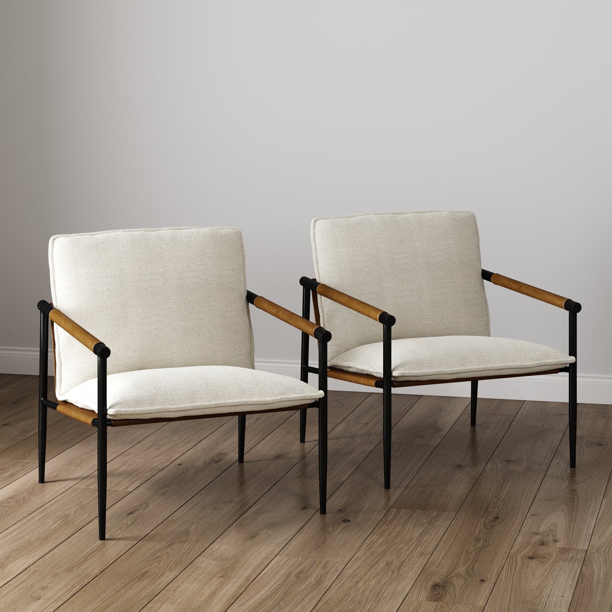 The Nathan James Boucle & Metal Accent Chairs (Set of 2) feature light beige linen weave cushions, wooden armrests, and black steel frames, positioned side by side on a wooden floor against a plain light-colored wall.