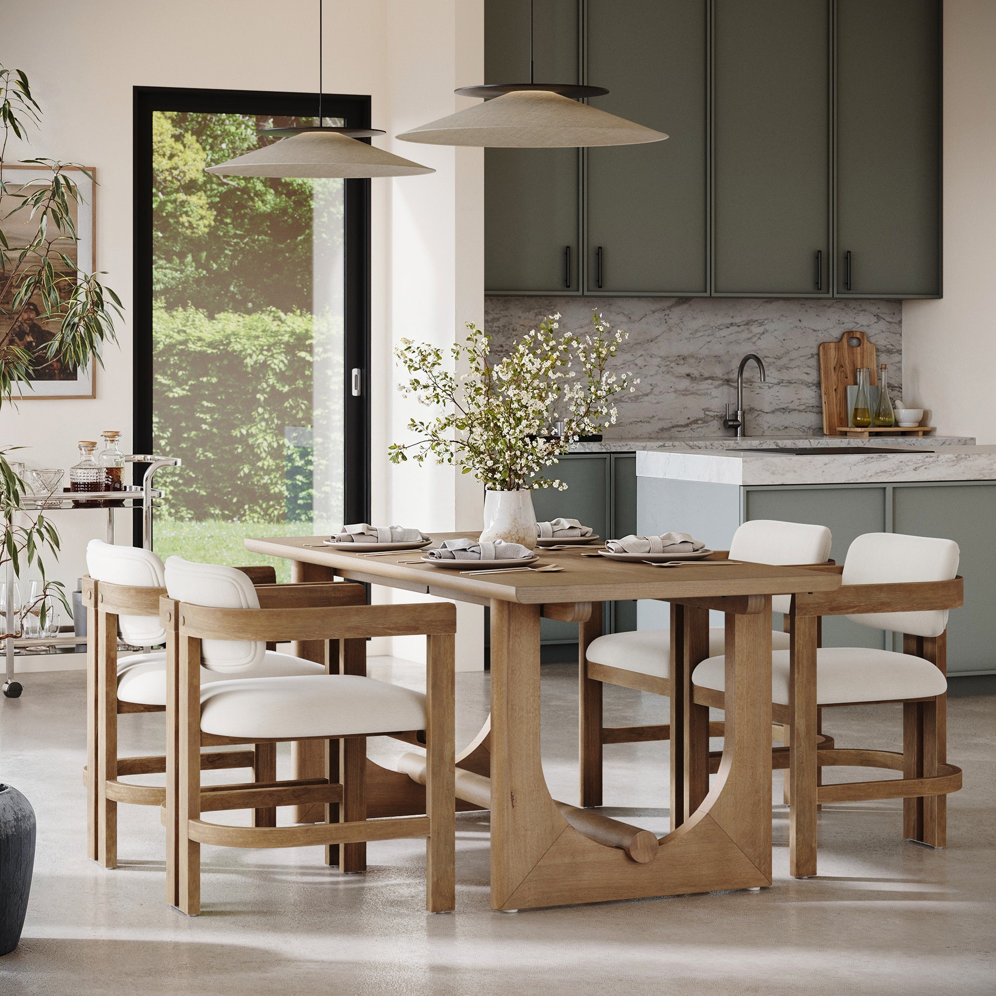 A modern dining room features a wooden table, six Nathan James Boucle Dining Chairs with curved backs and arms in light brown, a floral centerpiece, green cabinets, large windows with garden views, and two pendant lights above the table.