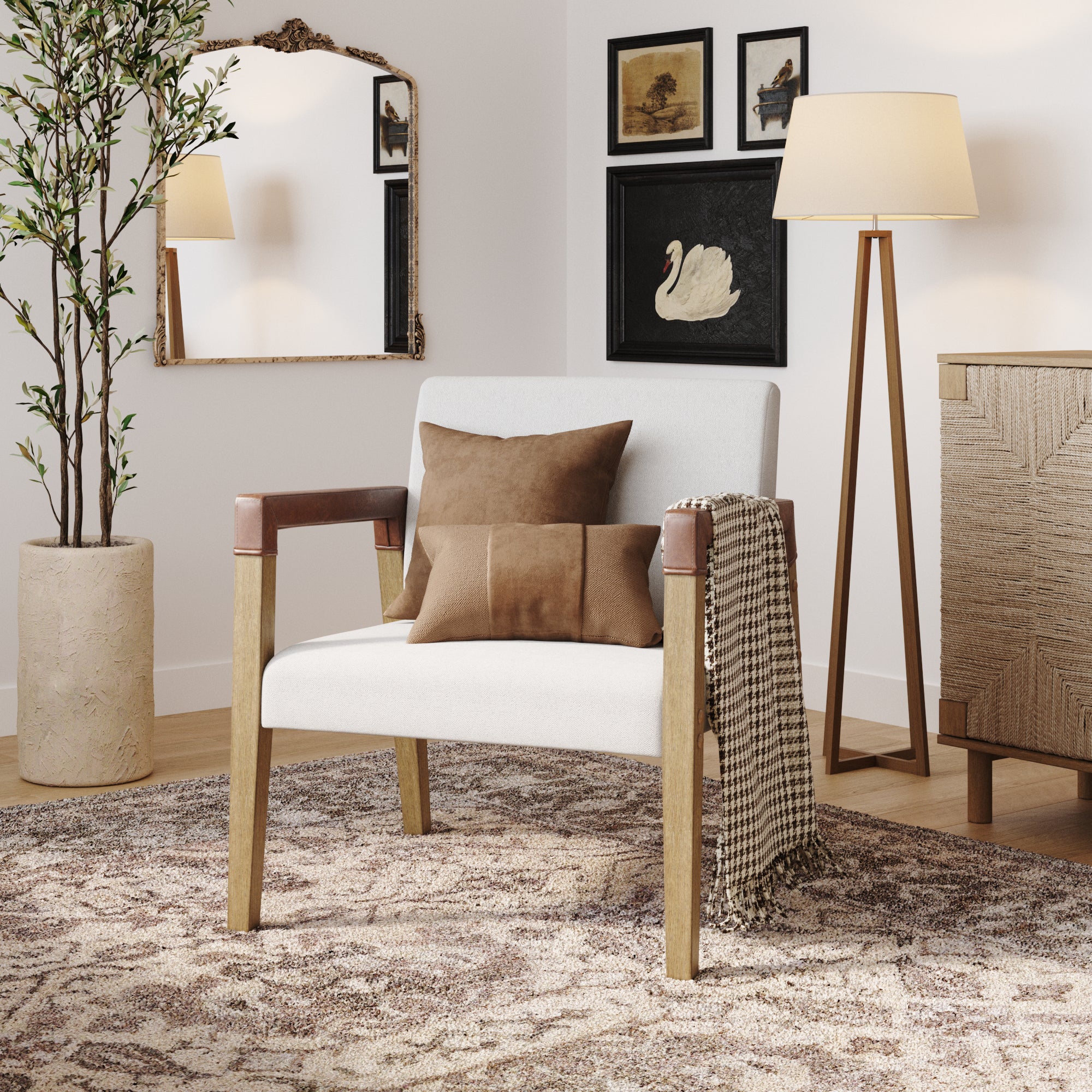 A modern living room with a white armchair, two brown cushions, and a checkered throw. Behind are framed art pieces, a floor lamp, a large mirror, a potted plant, and a patterned rug on a wooden floor.