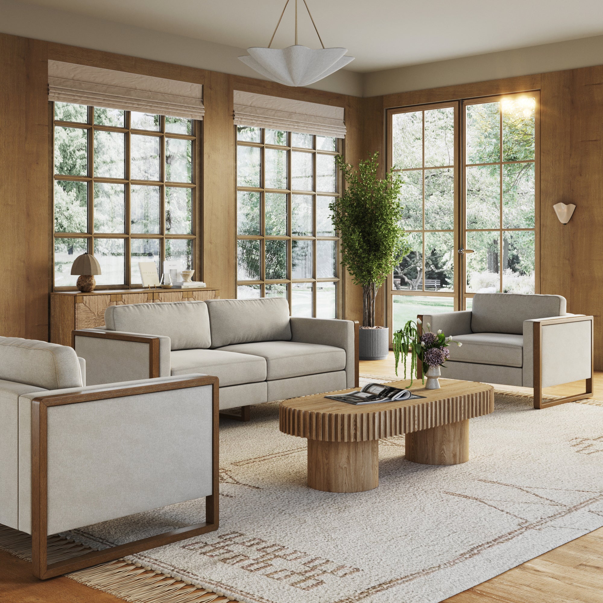 A modern living room with large windows, a beige Nathan James Soft Fabric Wood Frame Upholstered Armchair, neutral sofas, a wooden coffee table, beige rug, potted plant, and soft natural light creating a cozy minimalist atmosphere.