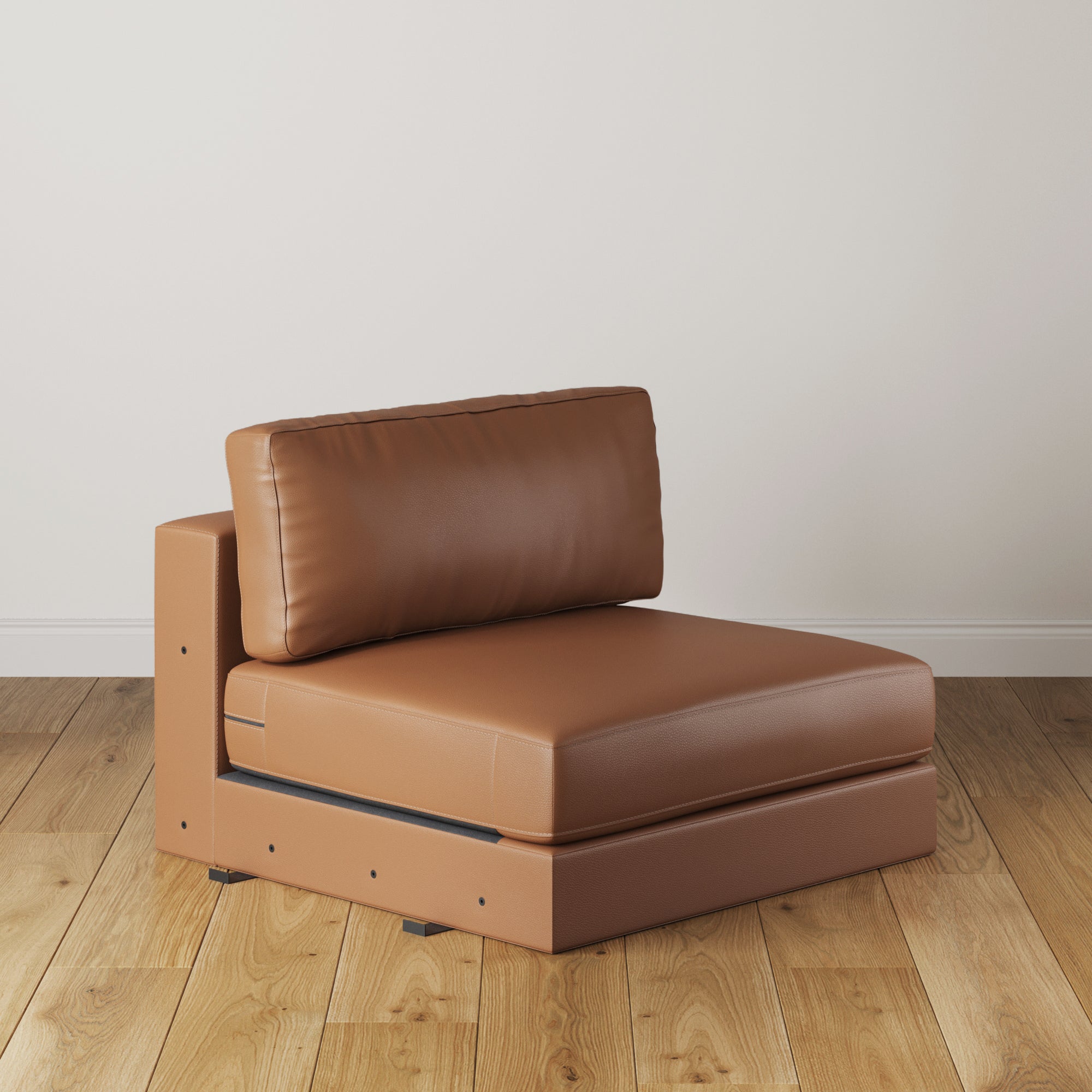 The Nathan James Upholstered Leather Sofa Standard Seat in camel, a modern armless modular piece with back cushion, rests on a light wood floor against a plain white wall.