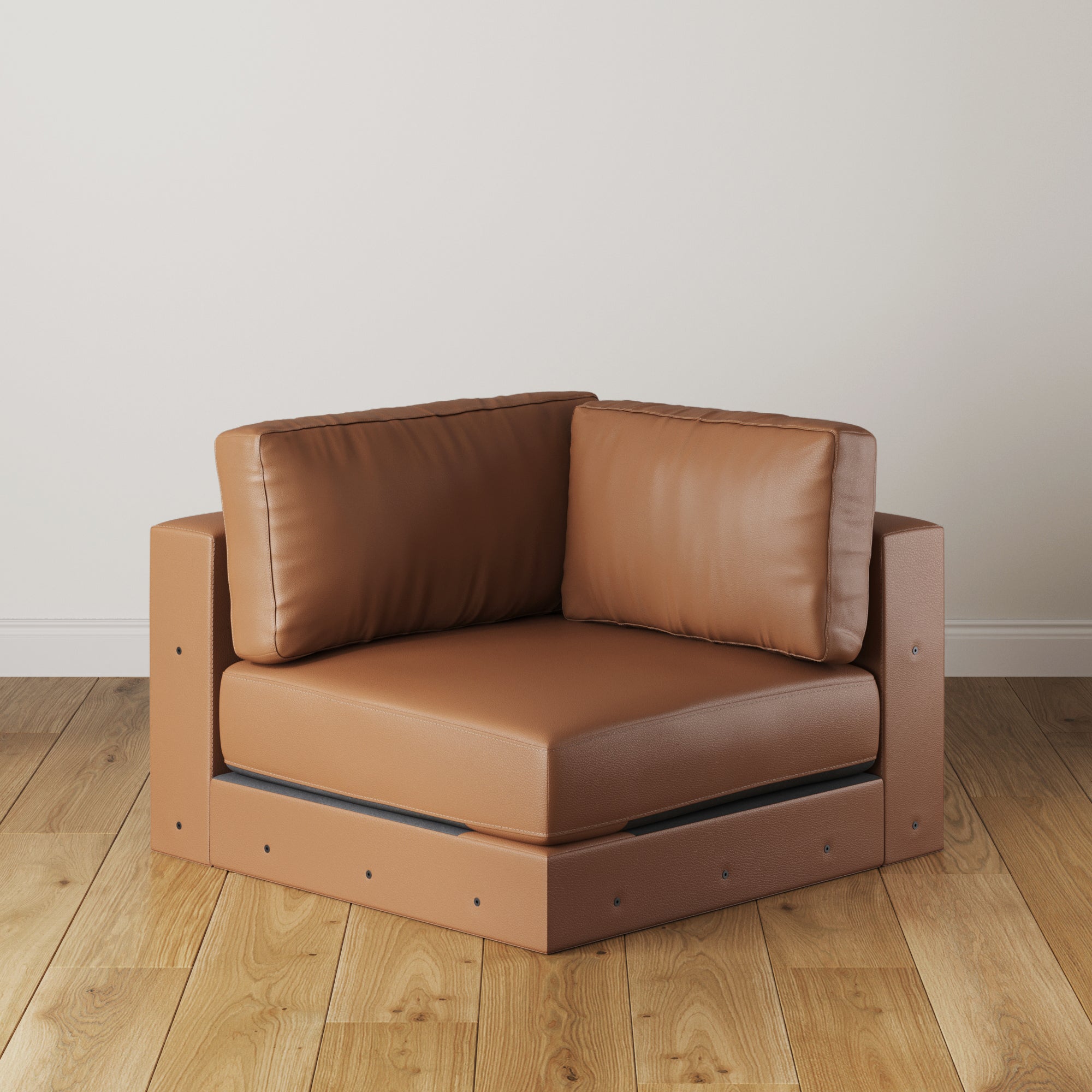 The Nathan James Upholstered Leather Sofa Corner Seat in camel features plush cushions and a boxy, geometric design, making it a modern modular piece perfect for placement against a white wall on wooden floors.