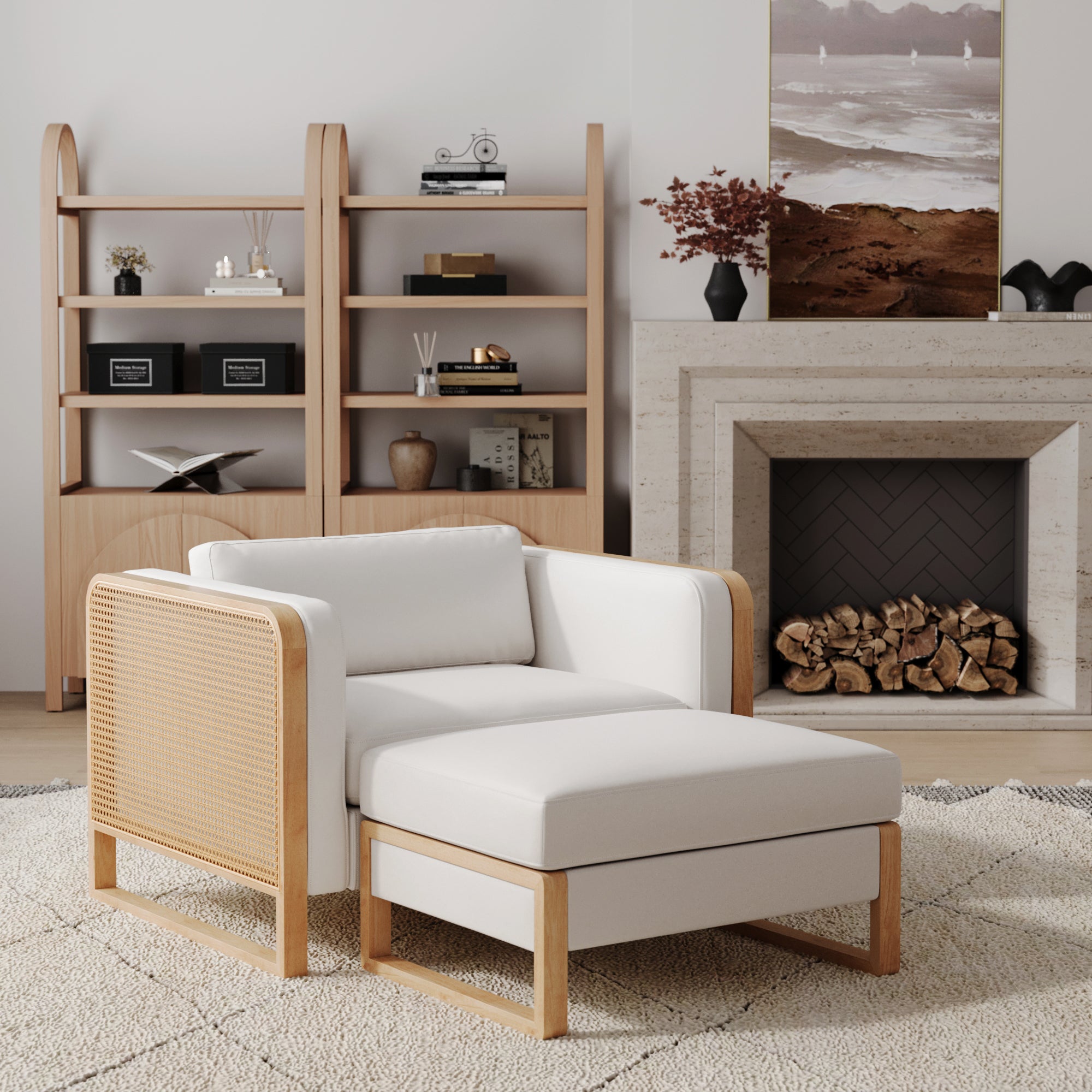 A cozy living room showcases the Nathan James Solid Wood Rattan Accent Chair with Ottoman Set in bisque on a beige rug, paired with a wooden bookshelf, log-stacked fireplace, and landscape artwork. Neutral earth tones create a calming vibe.