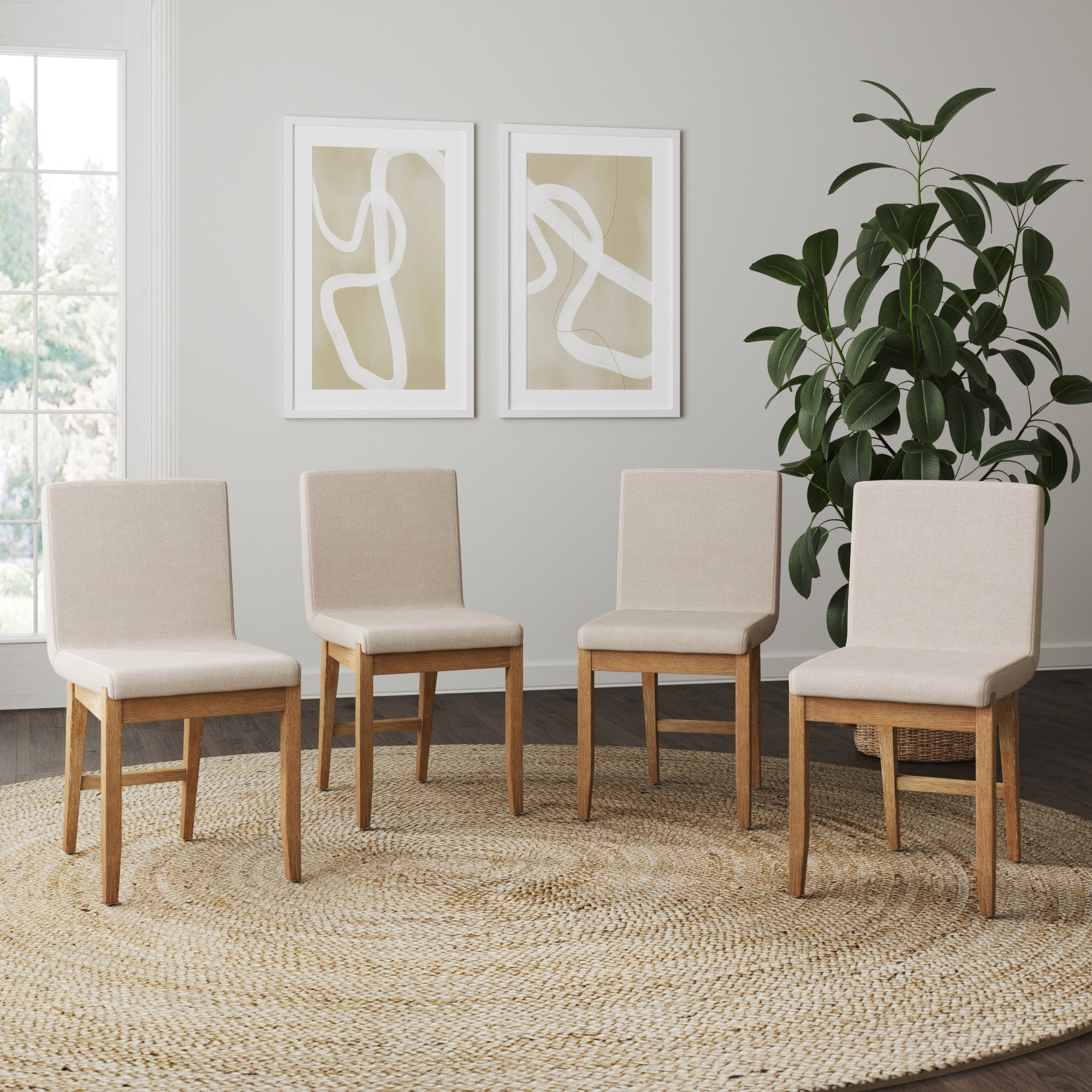 Four Nathan James Dining Chairs Light Brown Flax (Set of 4) with wooden legs are set on a round woven rug in a bright room, with two abstract artworks on the wall and a large green plant in the corner.