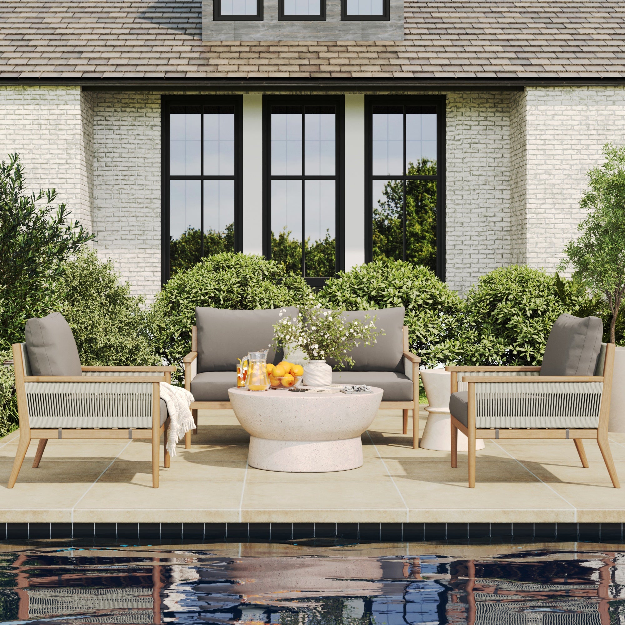 The Nathan James Outdoor 3 Piece Wood Patio Set features a loveseat and chairs with weatherproof acacia frames and removable cushion covers, paired with a round stone table, perfect for patios with garden views and large windows nearby.